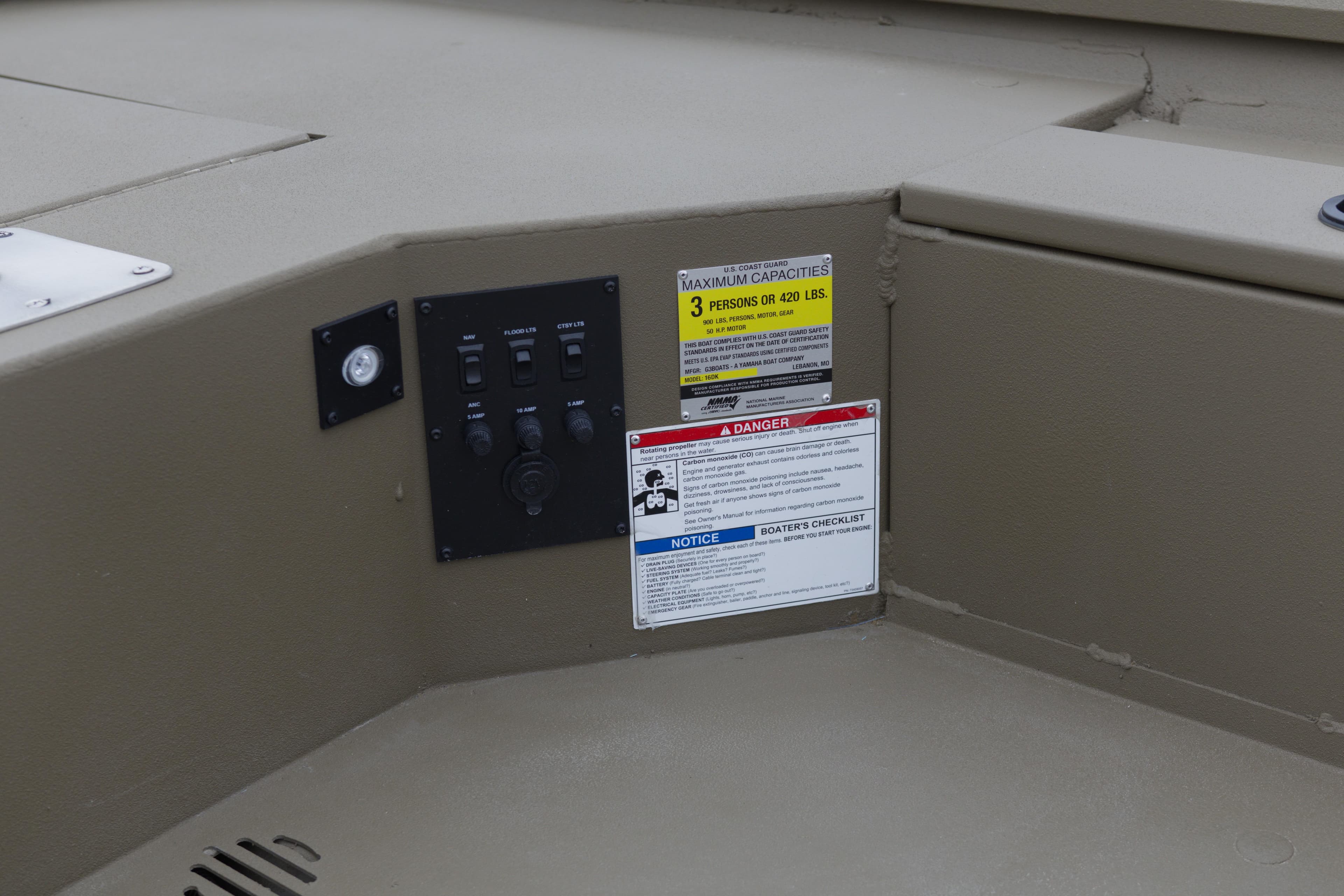 Control panel and safety labels on 2026 G3 Gator Tough 16 DK boat interior.