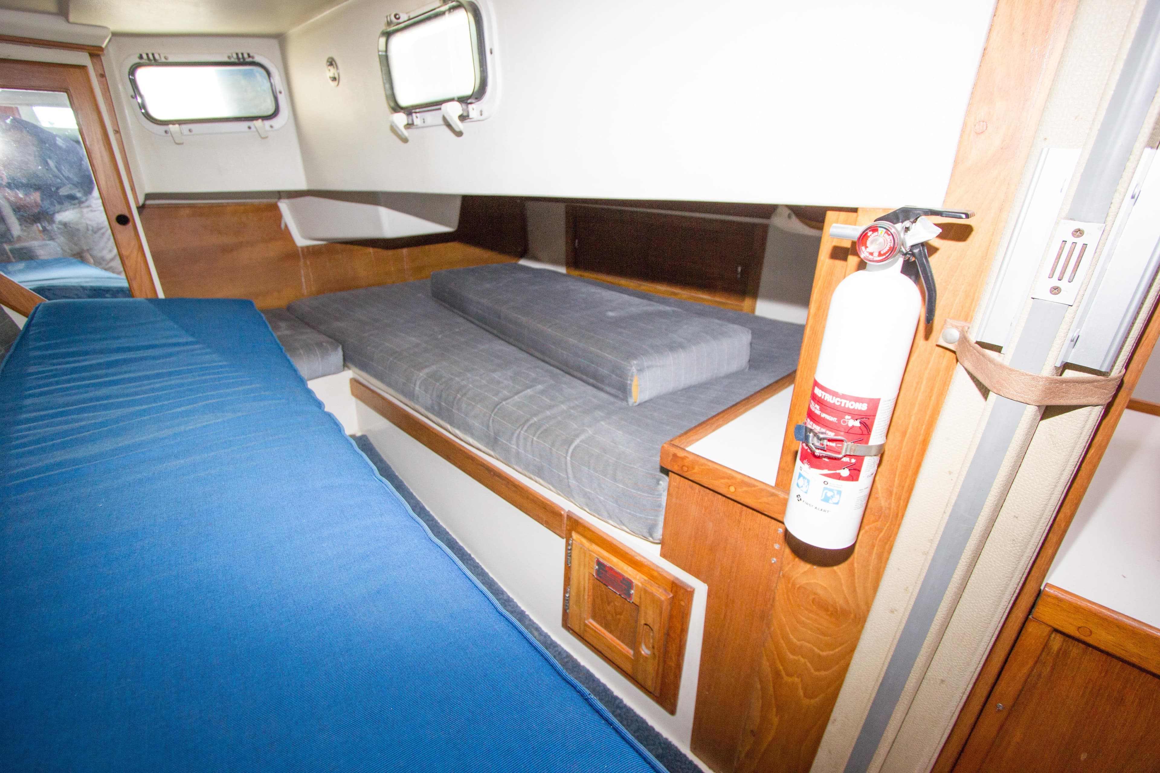 Interior cabin of a 1991 Catalina 36 sailboat with blue and gray cushions.