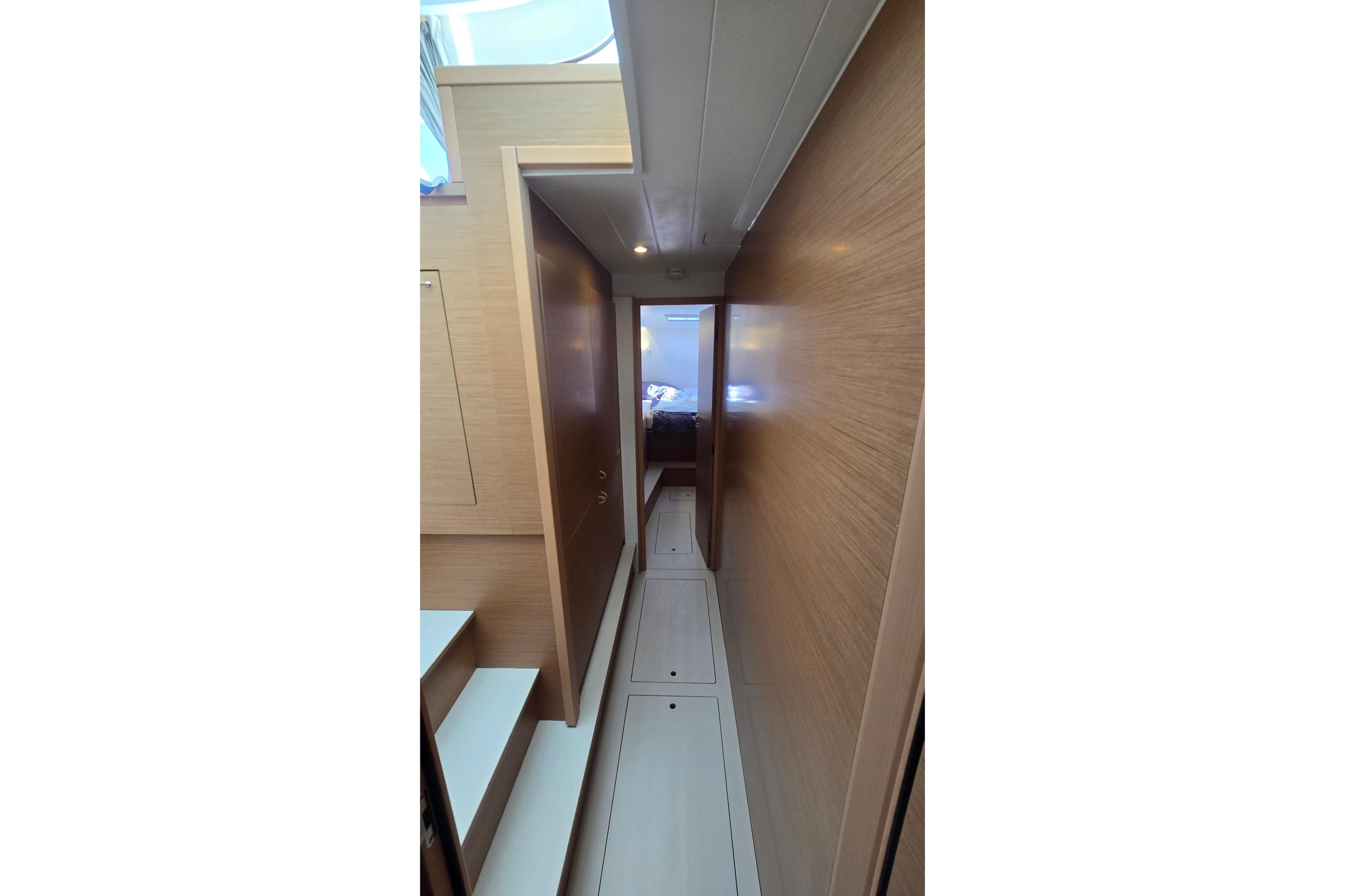 Narrow hallway inside 2024 Excess 14 yacht, featuring wooden walls and modern design.