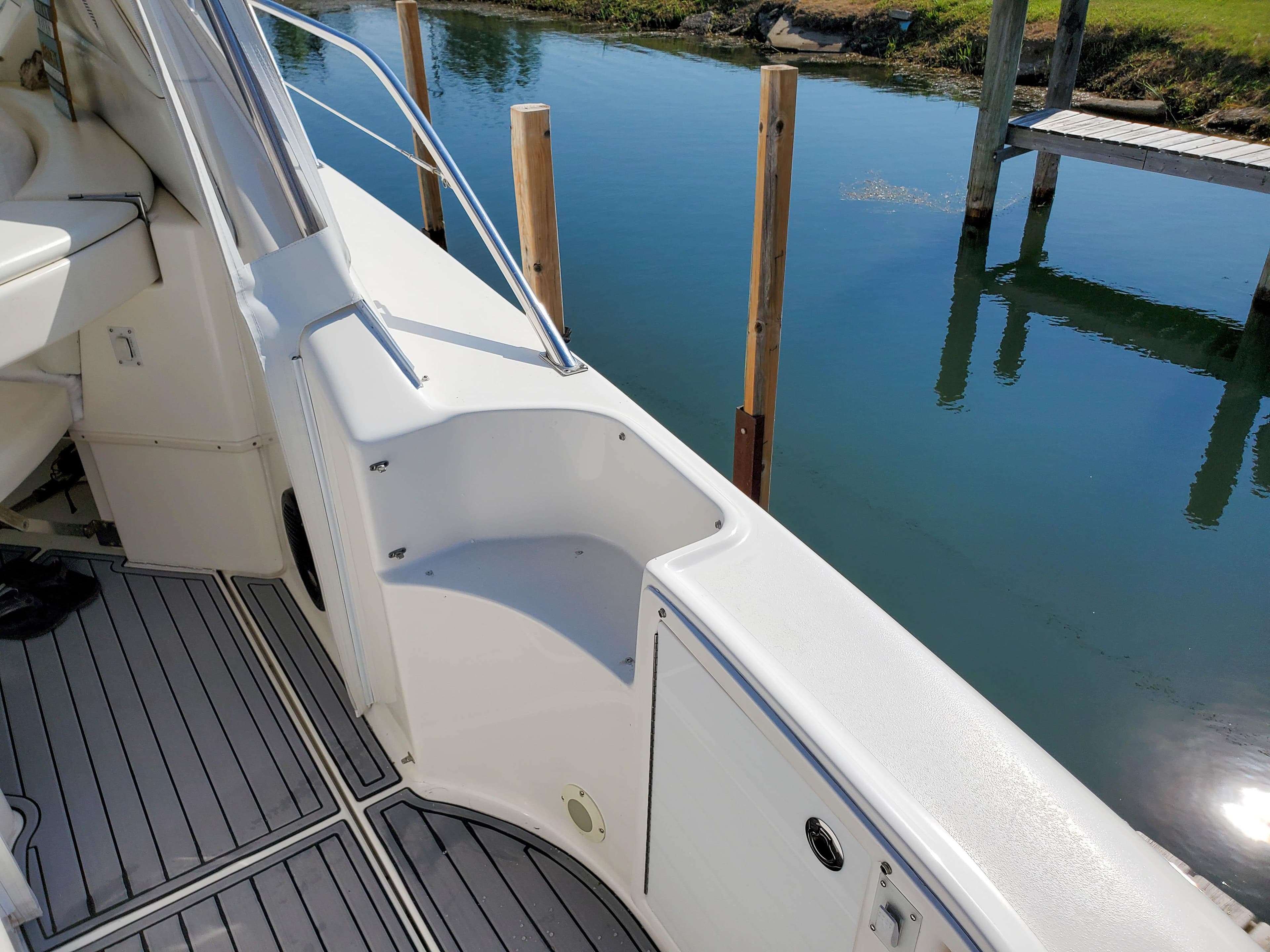 1997 Sea Ray 580 Super Sun Sport yacht deck with sleek white design and water view.
