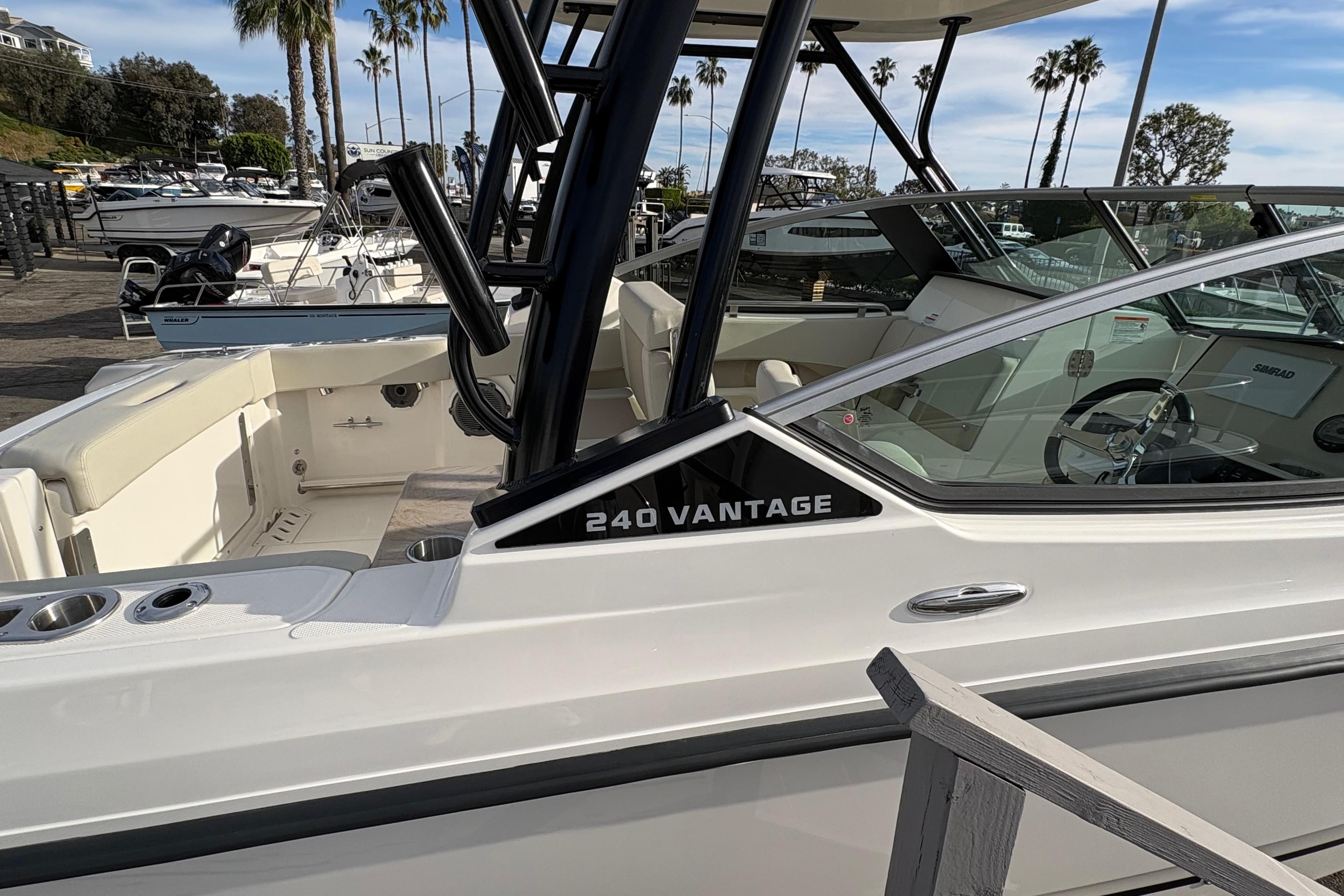 2026 Boston Whaler 240 Vantage boat docked, showcasing sleek design and spacious interior.