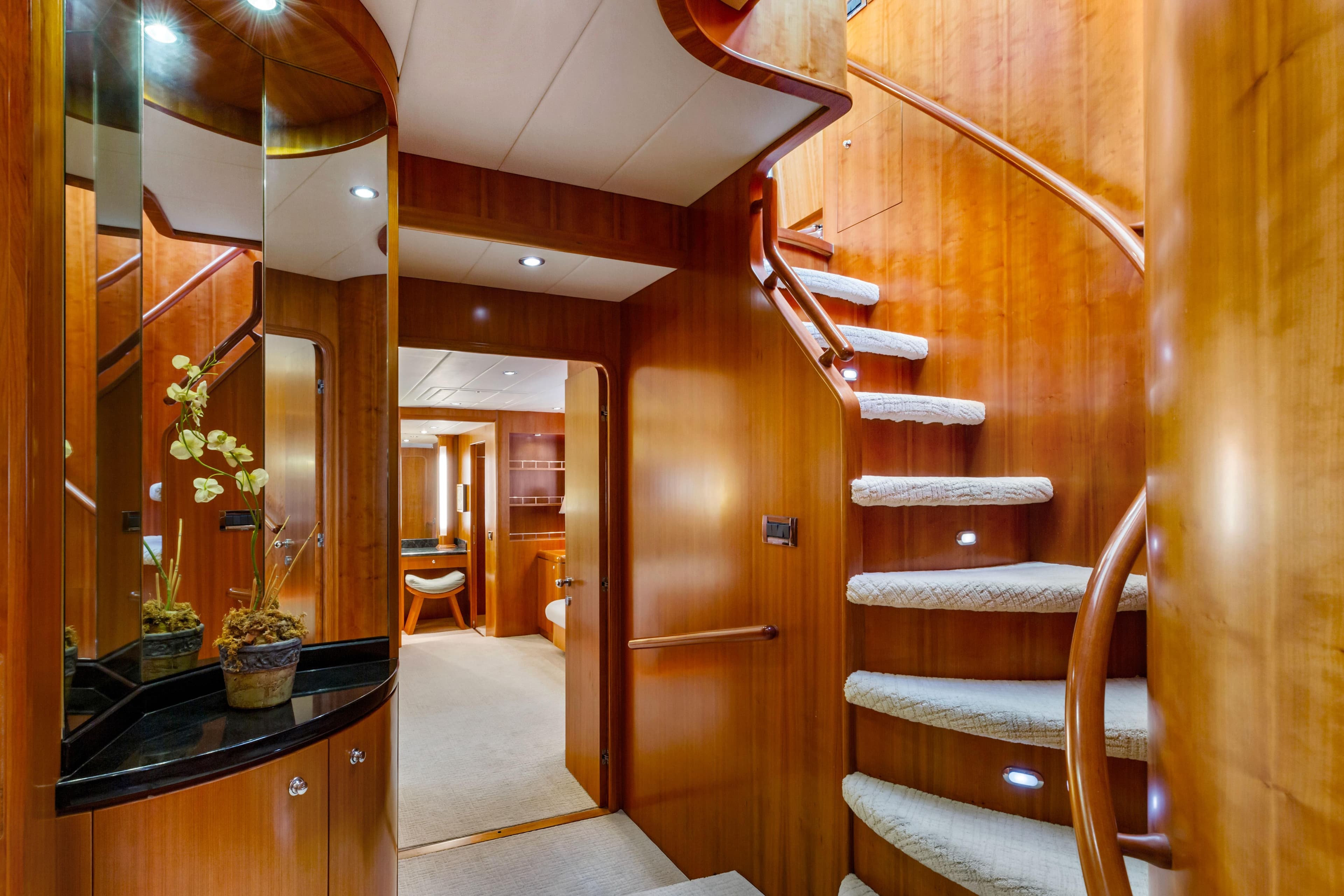 Luxurious wooden yacht interior with spiral staircase, elegant decor, and modern lighting, 2005 Custom model.