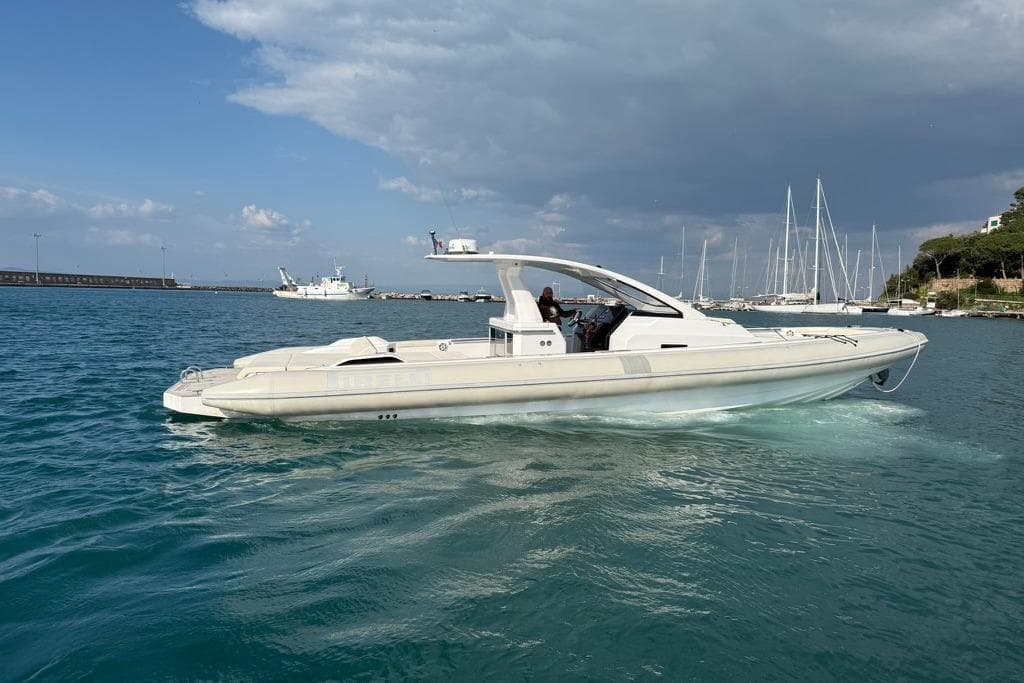 2022 Pirelli PIRELLI 42 boat cruising in a marina with sailboats in the background.