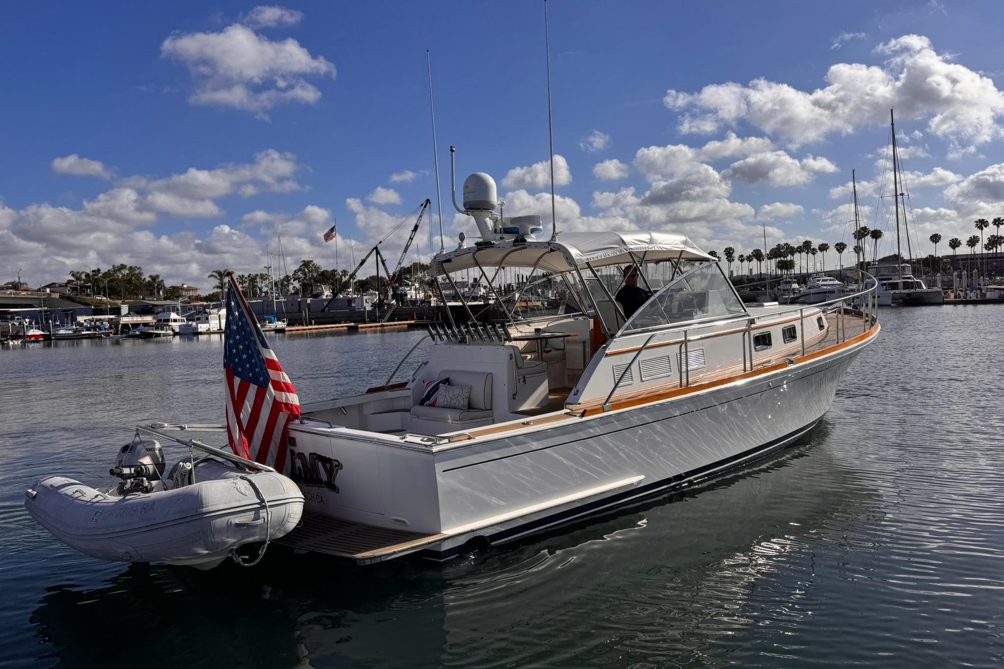 1999 Grand Banks 38 Eastbay EX yacht docked in sunny marina with American flag.