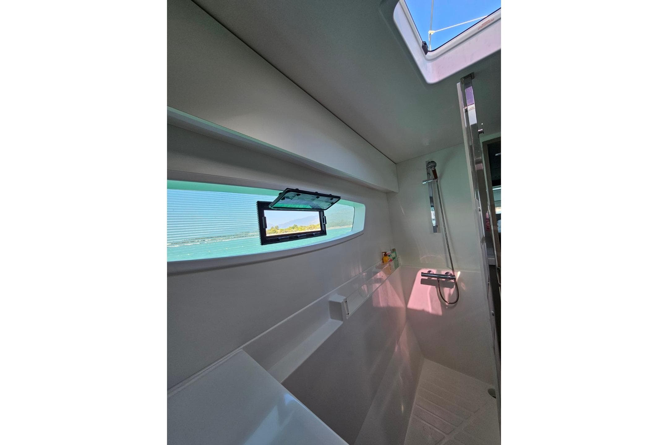 Interior view of 2021 Fountaine Pajot Astrea 42 yacht bathroom with ocean view window.