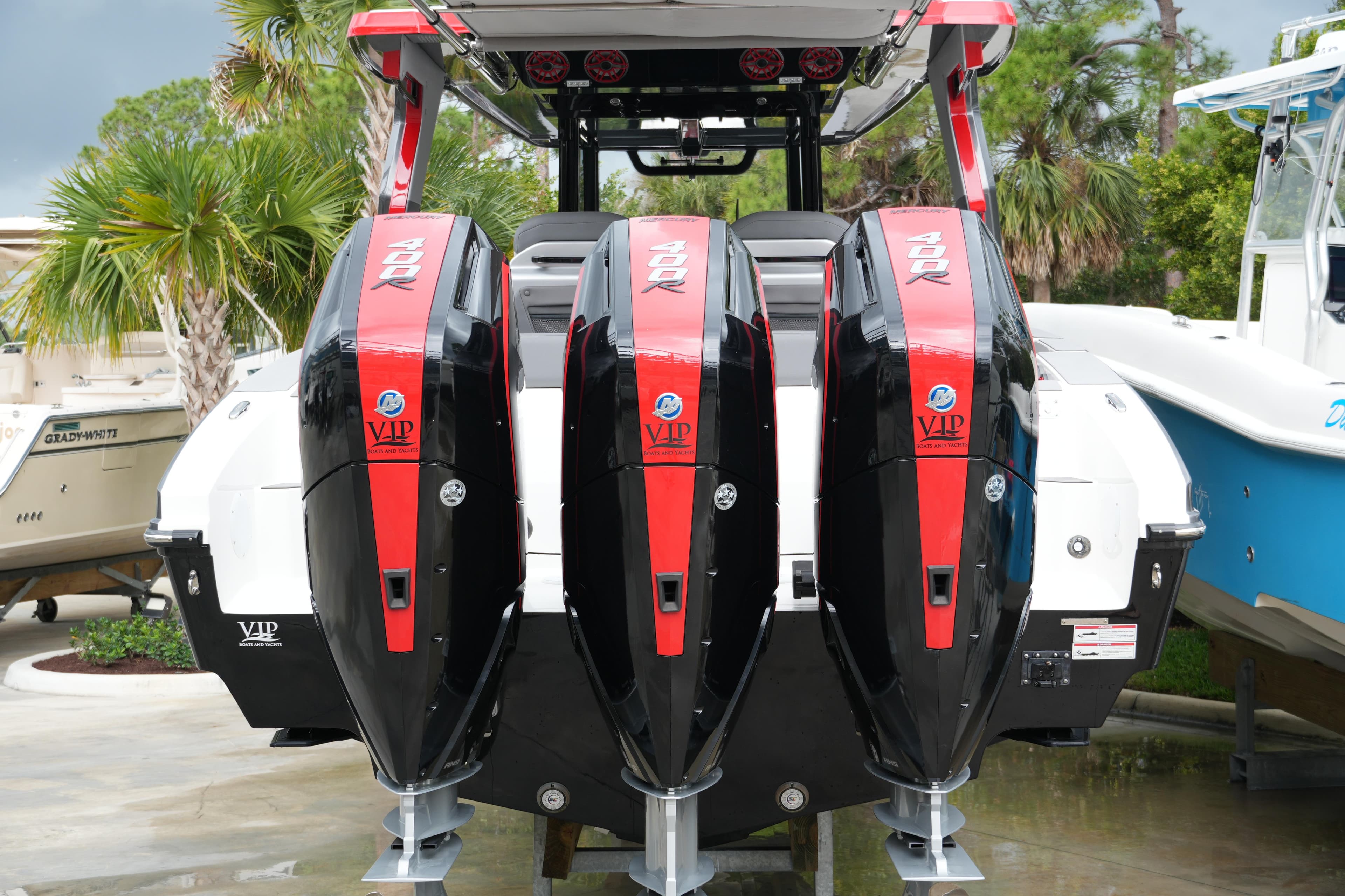 2025 Fountain 38 SCX boat with triple 400R outboard engines, docked near palm trees.