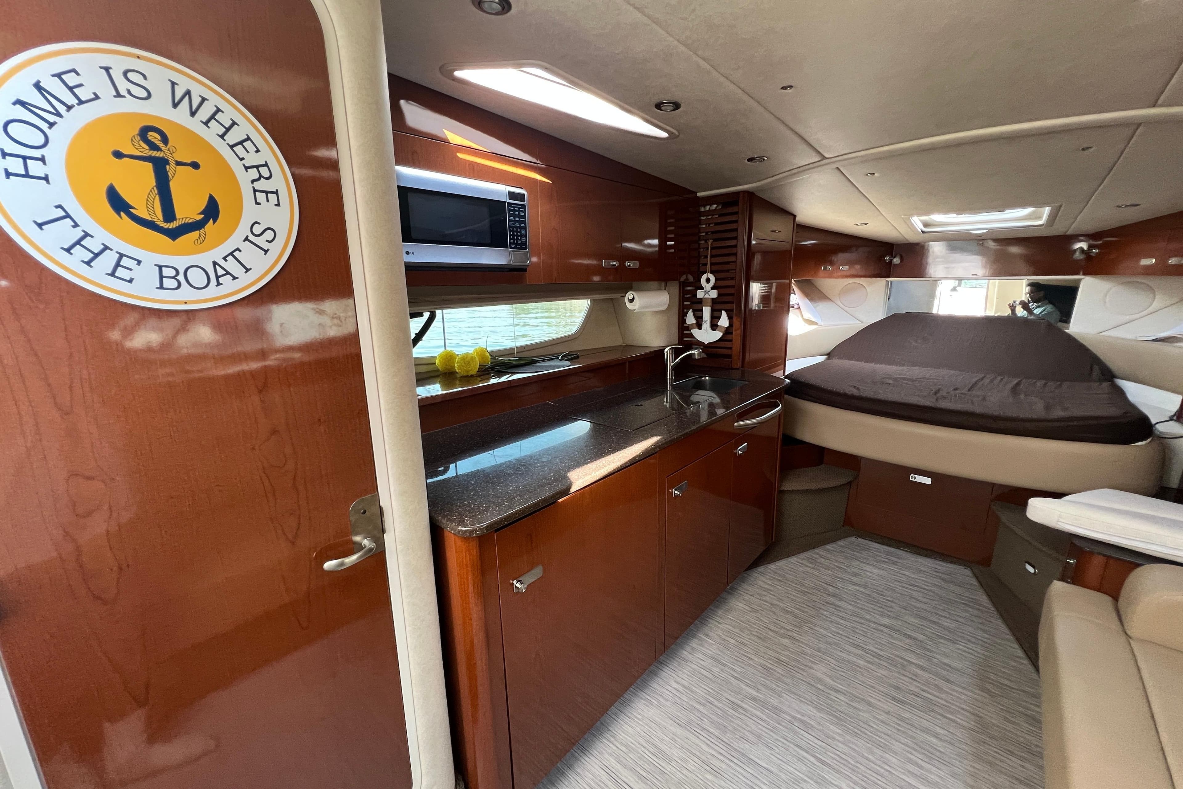 Interior of 2012 Sea Ray 370 Sundancer yacht with kitchenette and cozy sleeping area.