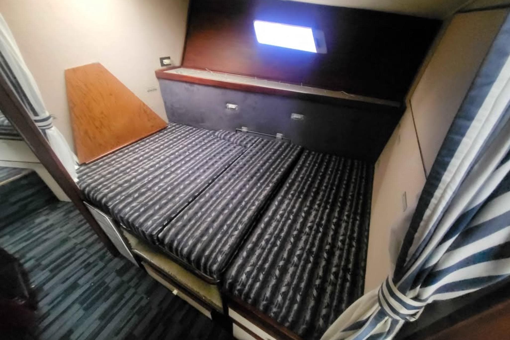 1987 Trojan F-36 Convertible cabin interior with striped bedding and window.