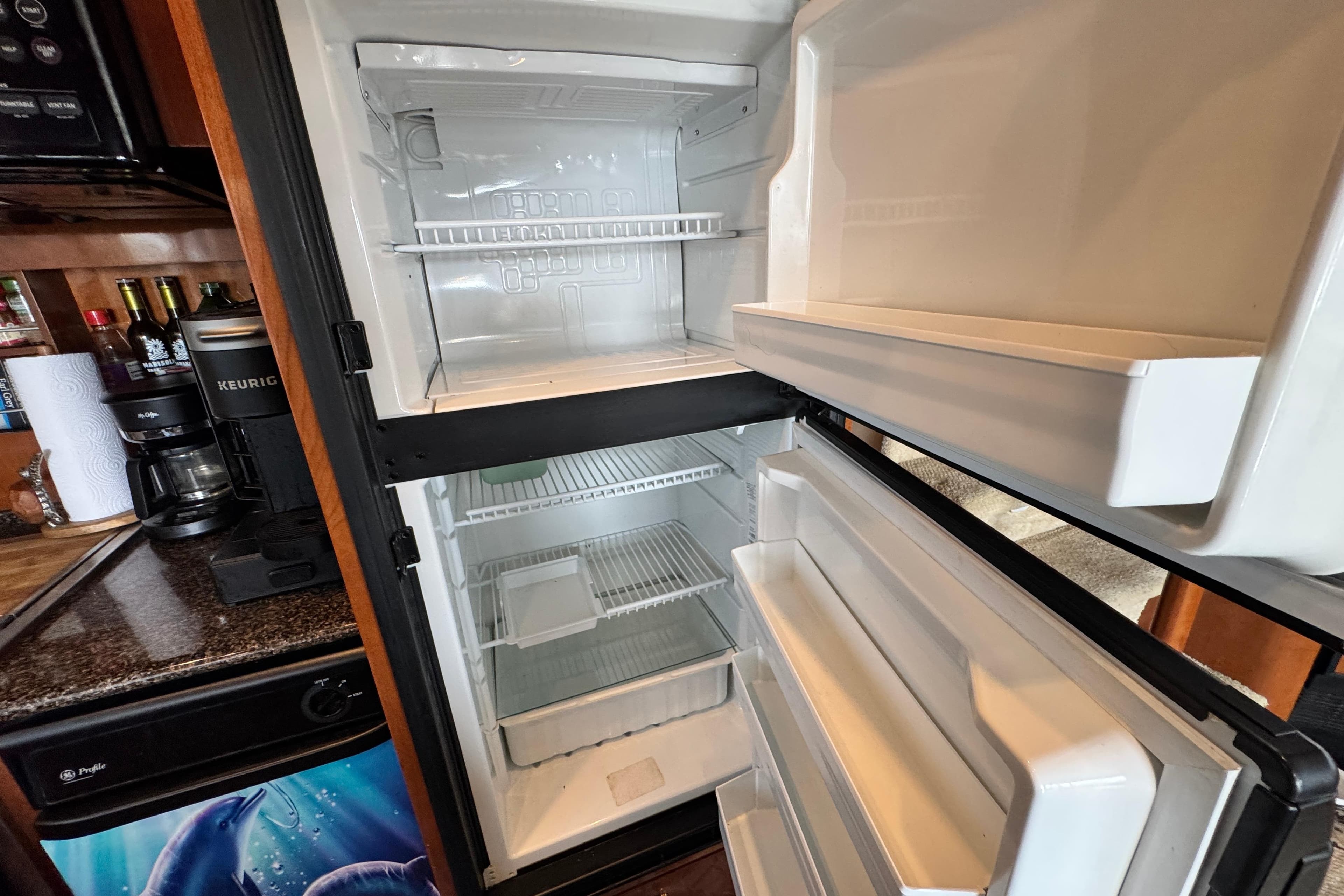 Open refrigerator in 2006 Meridian 490 Pilothouse yacht kitchen, showcasing interior storage space.