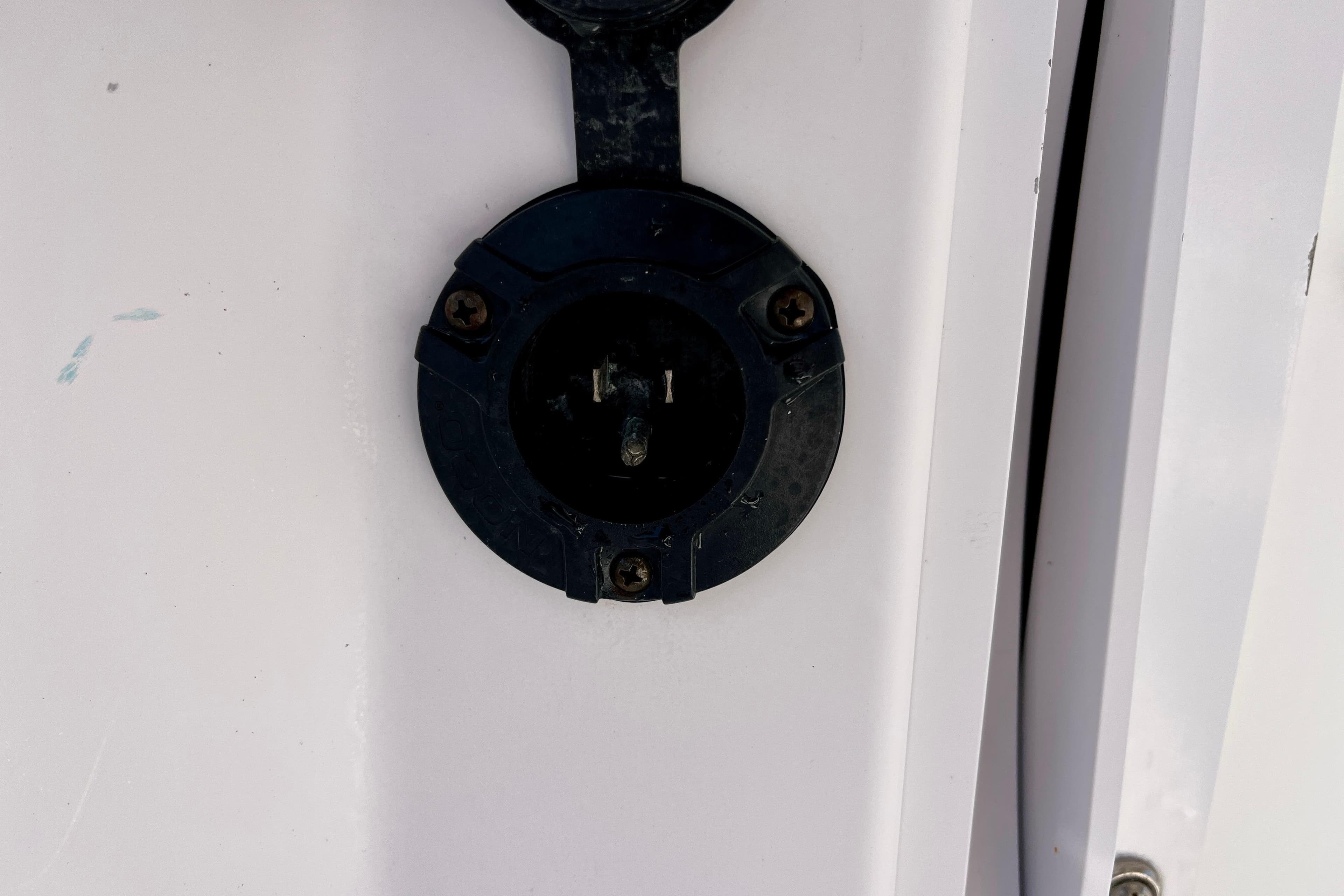 Close-up of a 2018 Pro-Line 26 Express boat's electrical socket on a white surface.