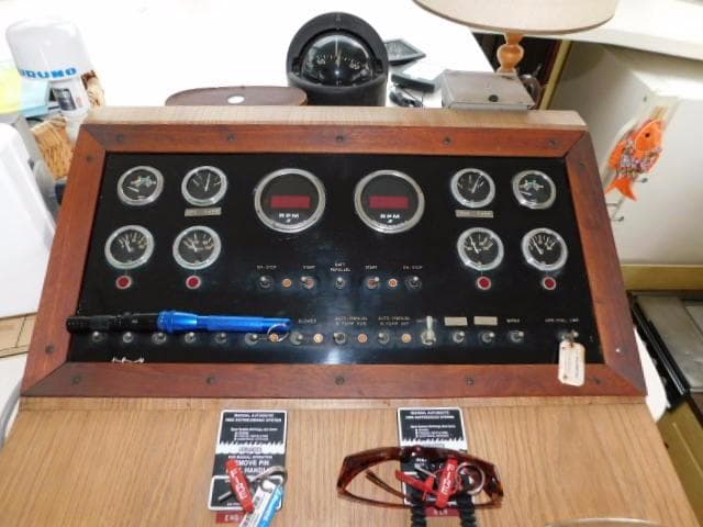 Control panel of a 1976 Bertram 42 Convertible boat with gauges and switches.