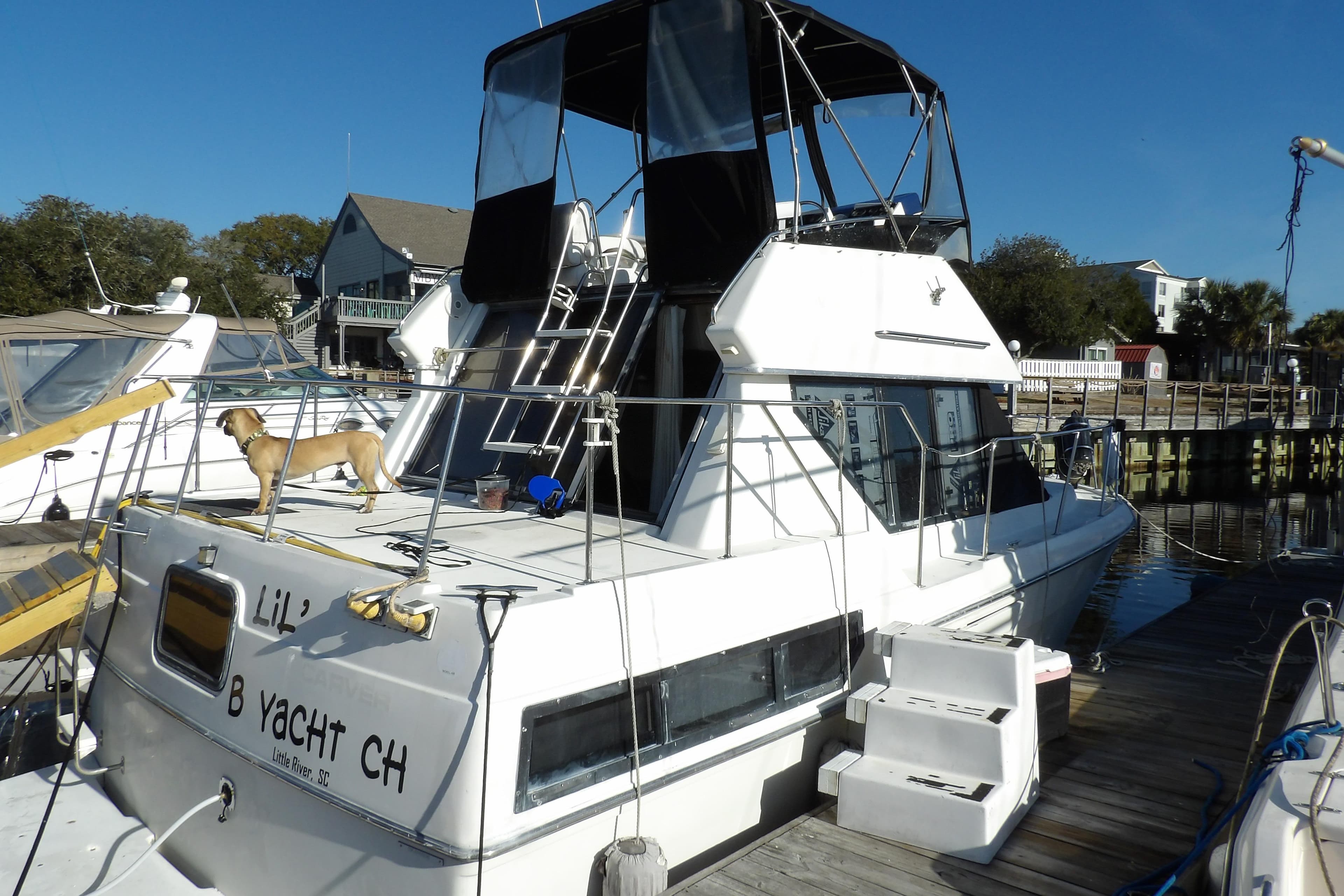 1992 Carver 28 Aft Cabin Motor Yacht docked, featuring a dog on deck.