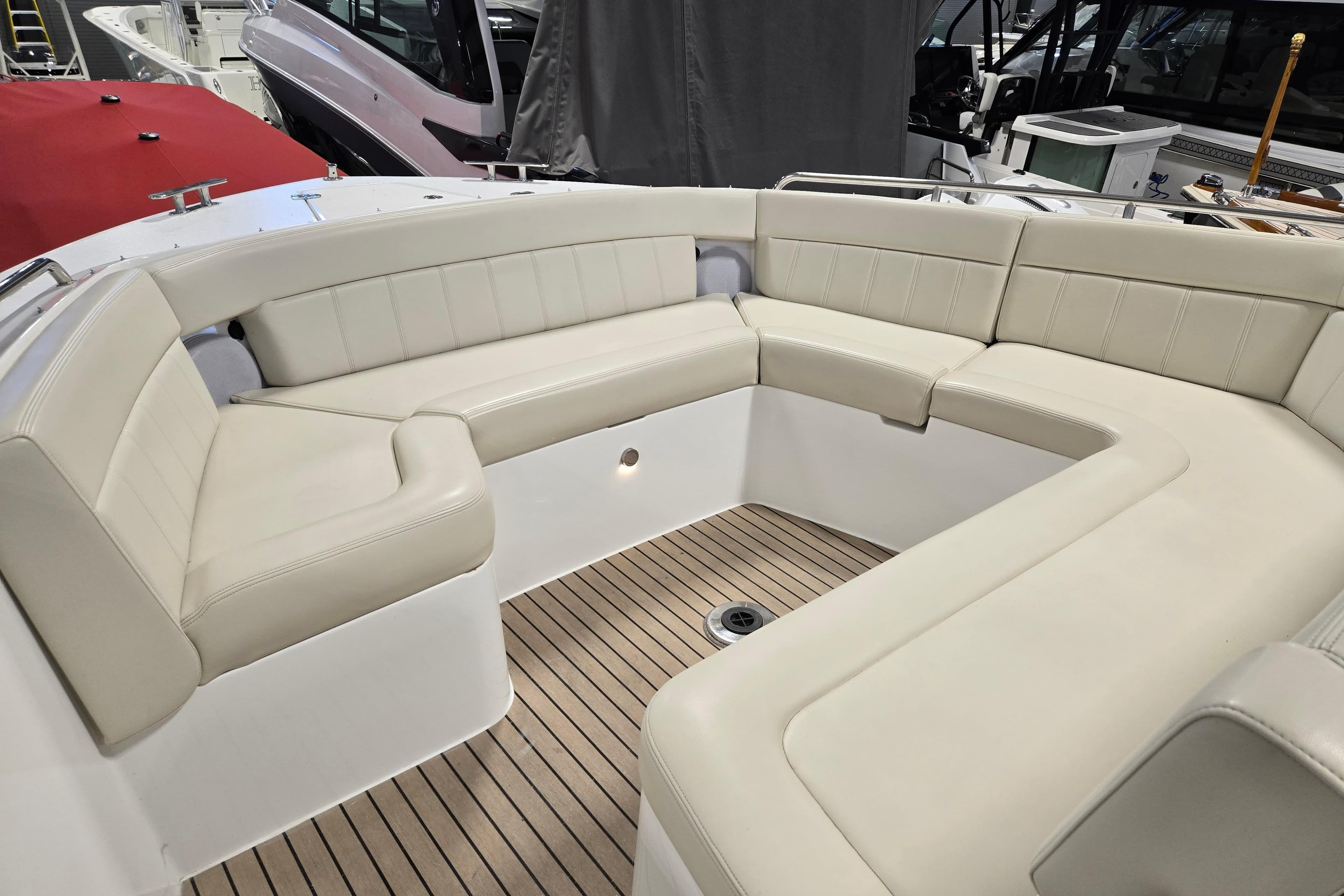 Luxurious seating area on 2023 MJM 4 boat with elegant design and wood flooring.
