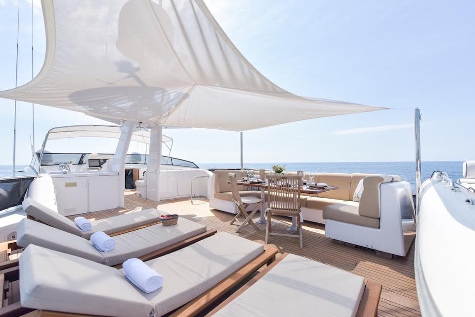 Luxurious 1984 W.A. Souter & Sons yacht deck with sun loungers and dining area.
