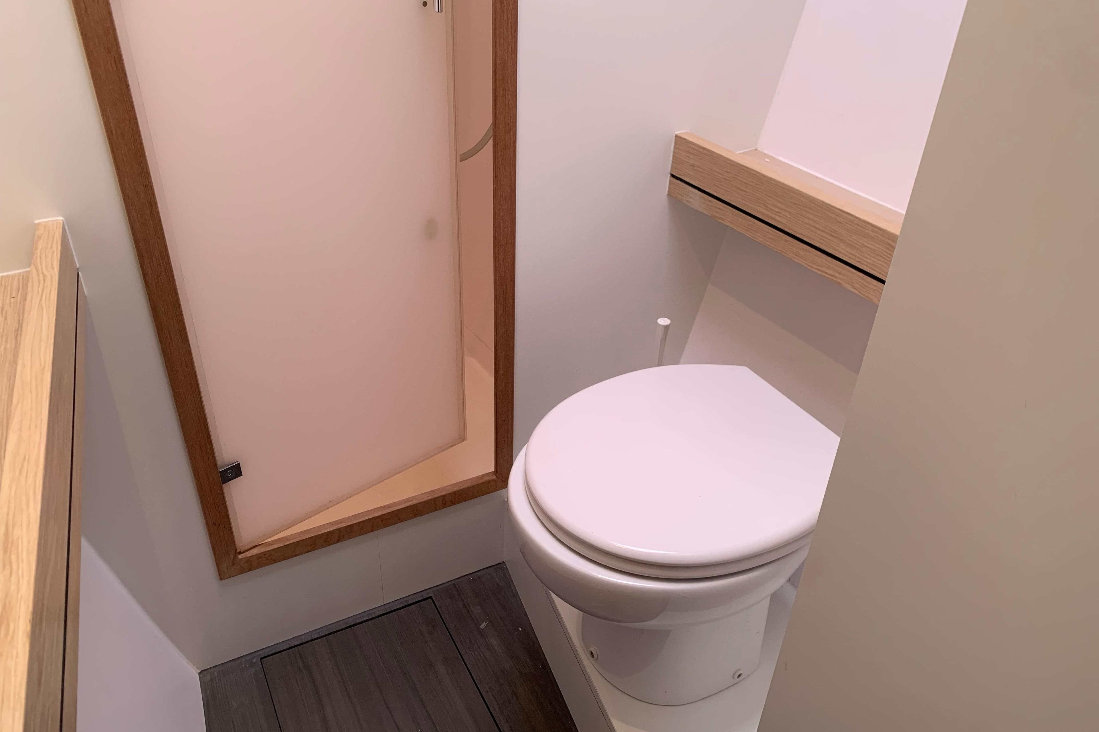 Bathroom interior of 2021 Outremer 51 yacht with modern toilet and wooden accents.