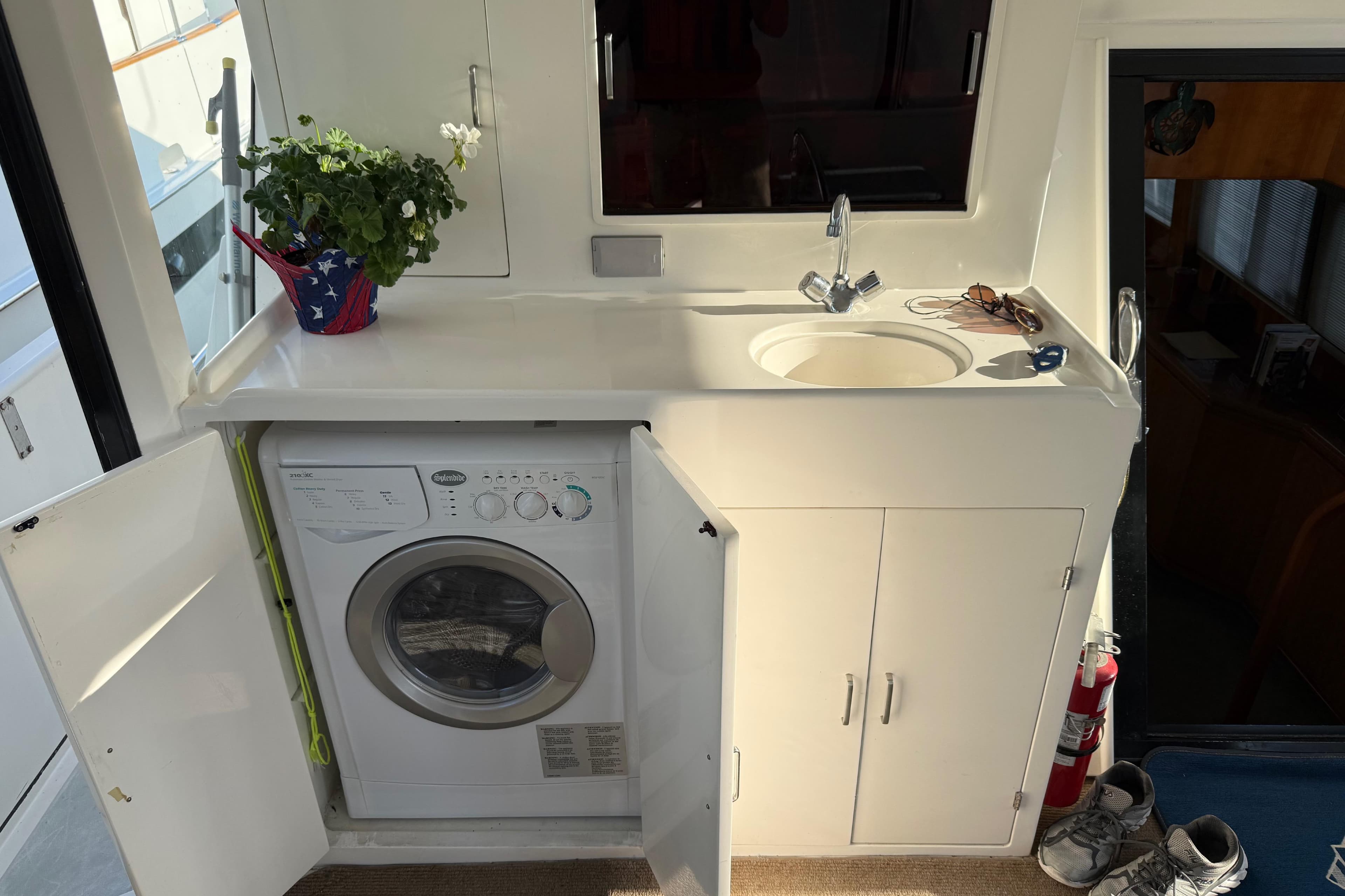 2000 Novatec Cockpit Motor Yacht interior with sink, washing machine, and potted plant.