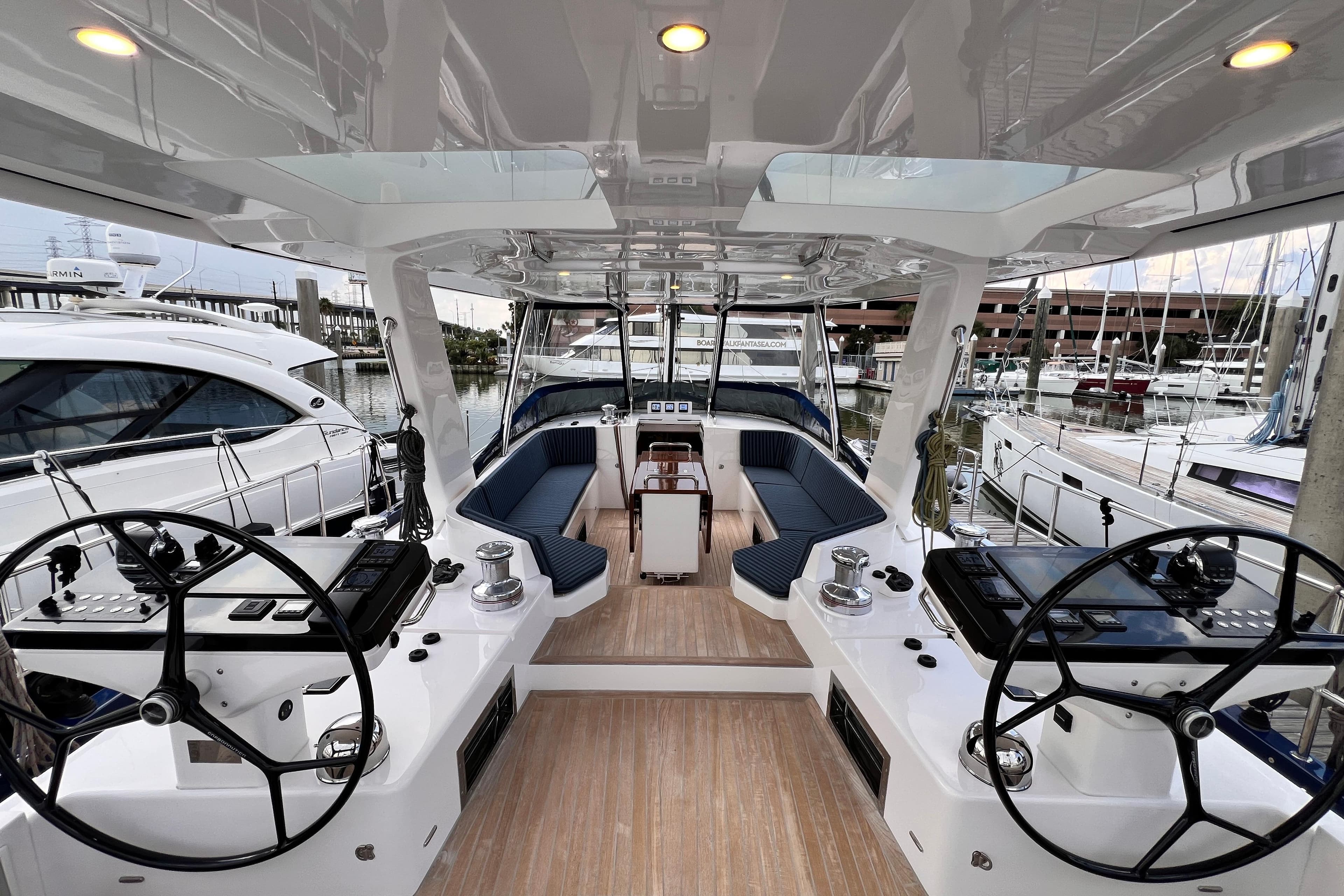 Luxurious 2024 Hylas H57 yacht cockpit with dual steering wheels and elegant seating.