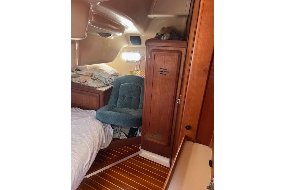 Interior of a 1997 Hunter 430 sailboat cabin with wooden finishes and cozy seating.