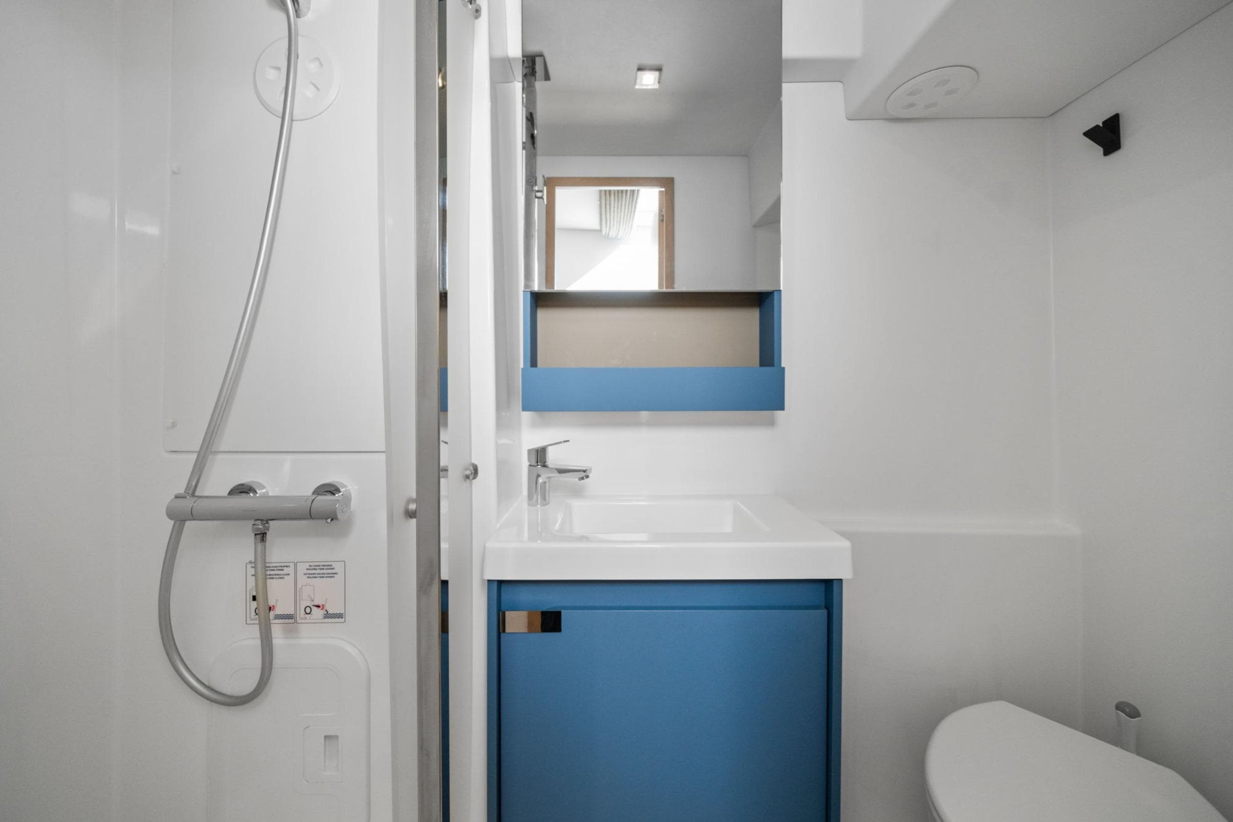 2024 Fountaine Pajot Aura 51 Catamaran bathroom with modern shower and blue vanity.