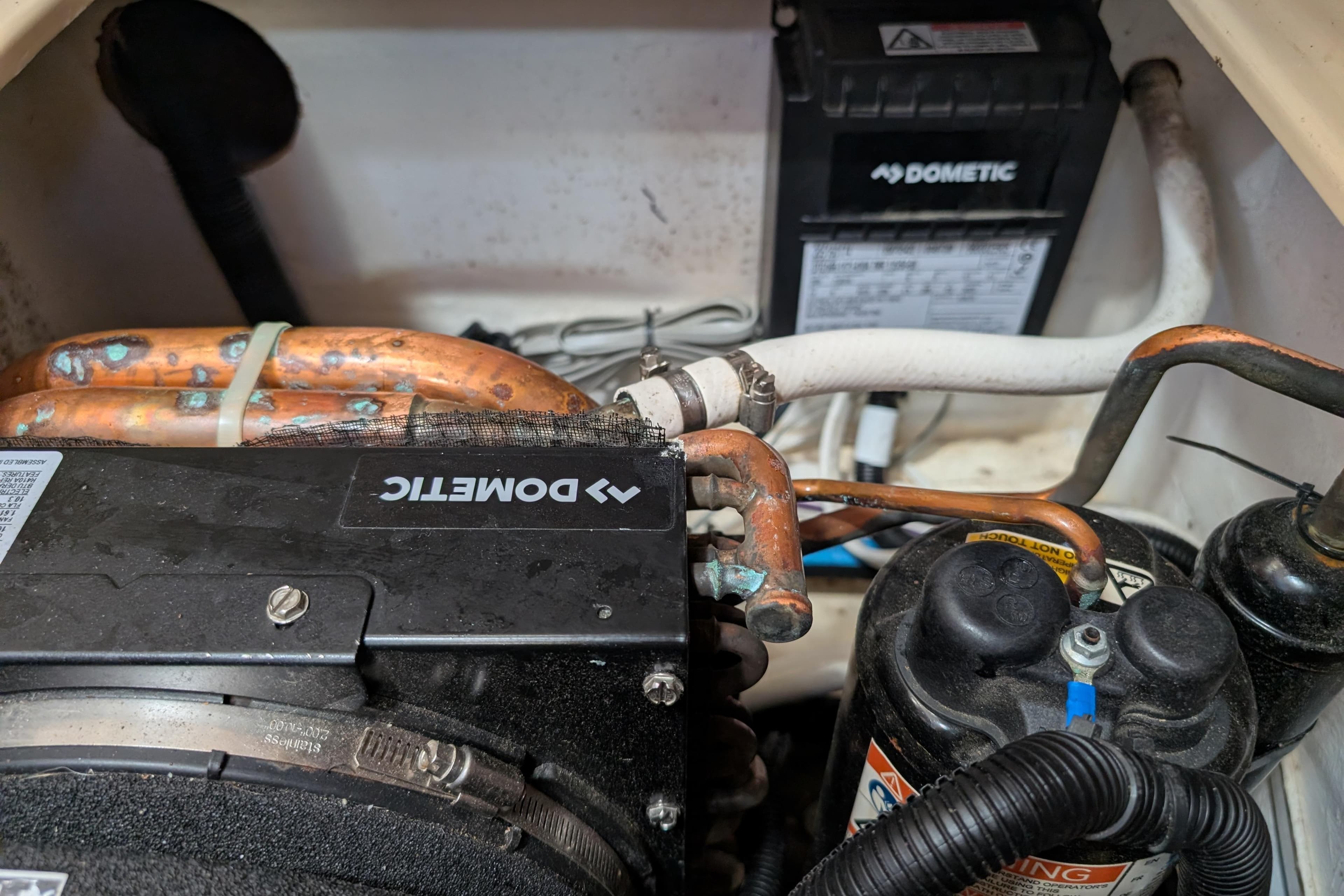 Engine compartment of a 1999 Island Packet 320 with Dometic components and copper piping.
