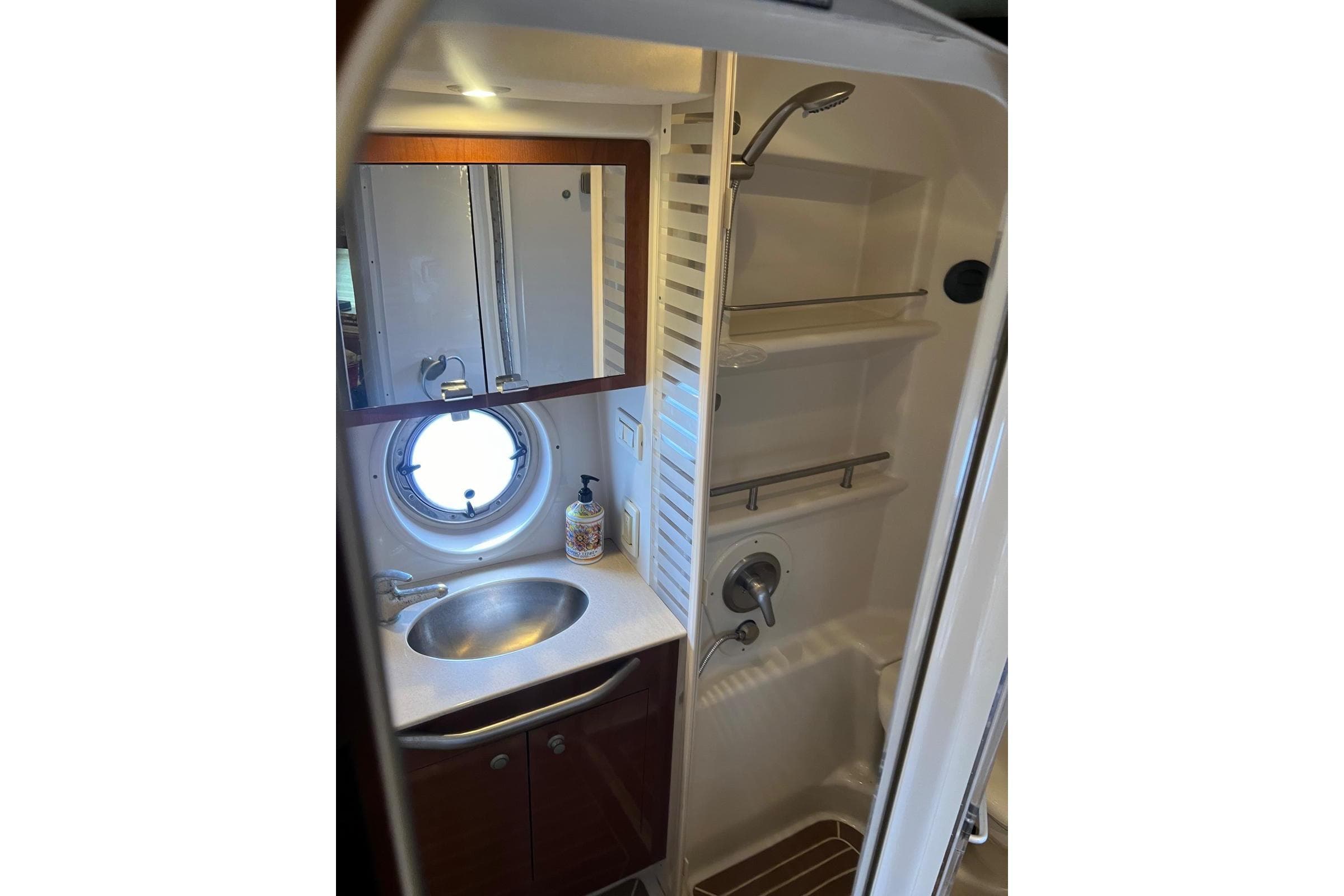 Bathroom interior of 2009 Sea Ray Sundancer 350 yacht with sink, mirror, and shower.