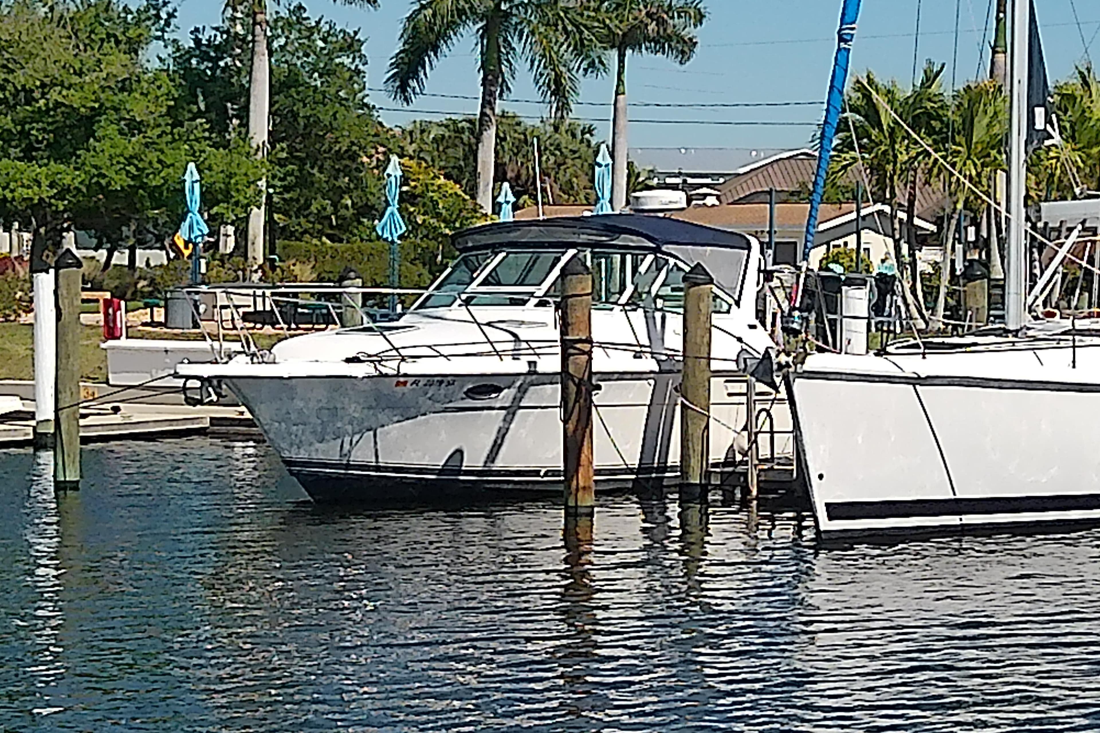 2000 Tiara Yachts 3100 Open docked at a marina with palm trees in the background.