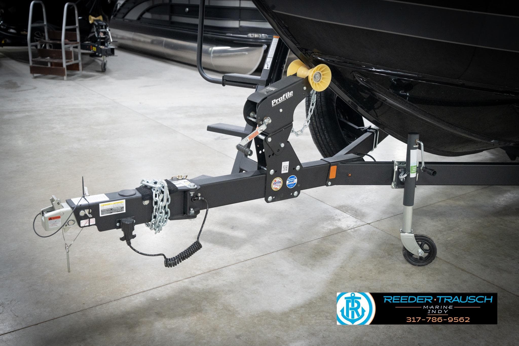 Trailer hitch of 2026 Lund 2275 Baron boat in showroom setting.