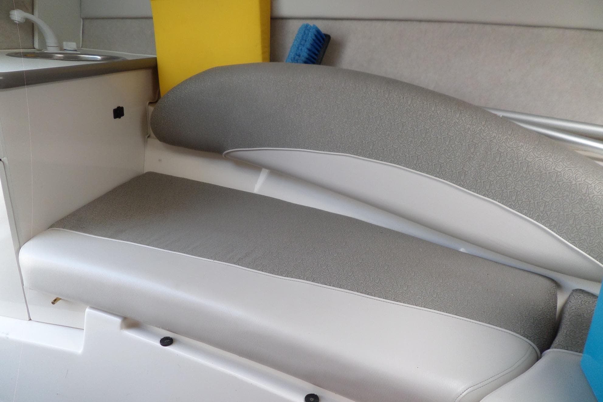 Interior seating of 2003 Maxum 2400 SC boat with sink and storage.