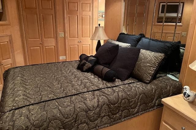 Luxurious bedroom in a 2008 Fantasy Houseboat with elegant bedding and wooden decor.