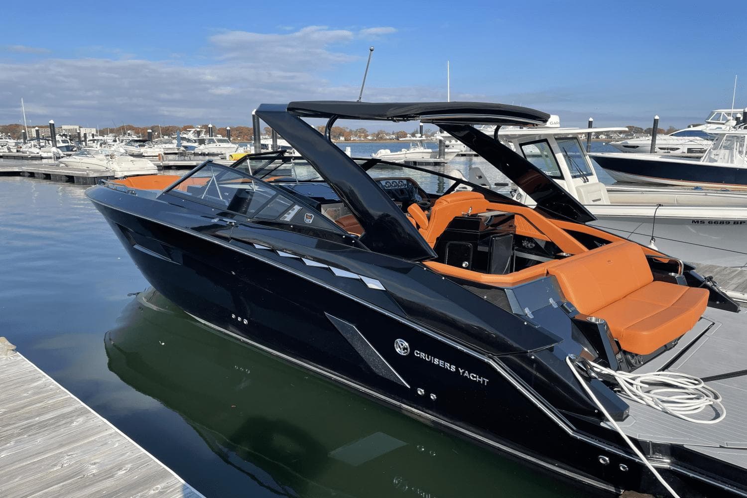 2021 Cruisers Yachts 338 CX docked, featuring sleek black design and orange seating.