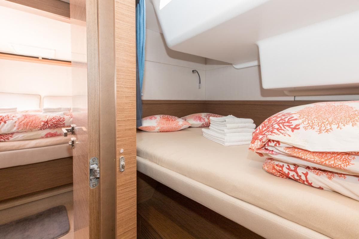 Luxurious cabin interior of 2019 Lagoon 50 yacht with coral-themed bedding.