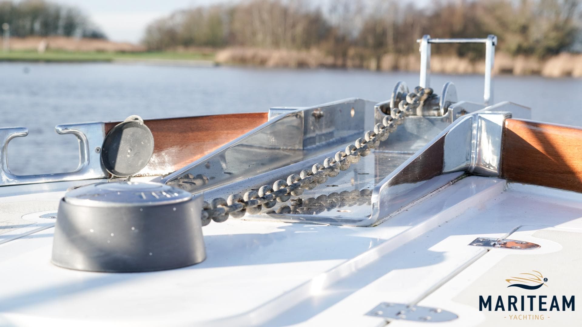 Bow of 2000 Grand Banks Eastbay 38 HX yacht with anchor chain, on calm water.