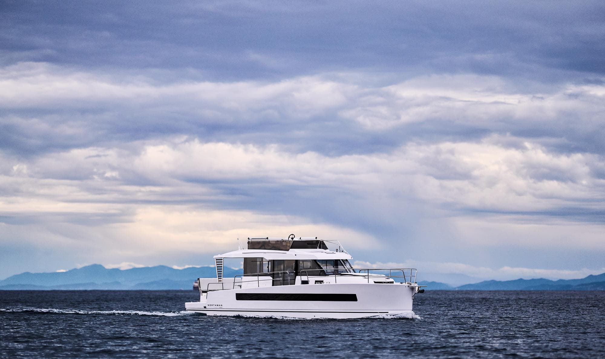 Modern Northman 1300 yacht cruising on open sea under cloudy sky, 2025 model.