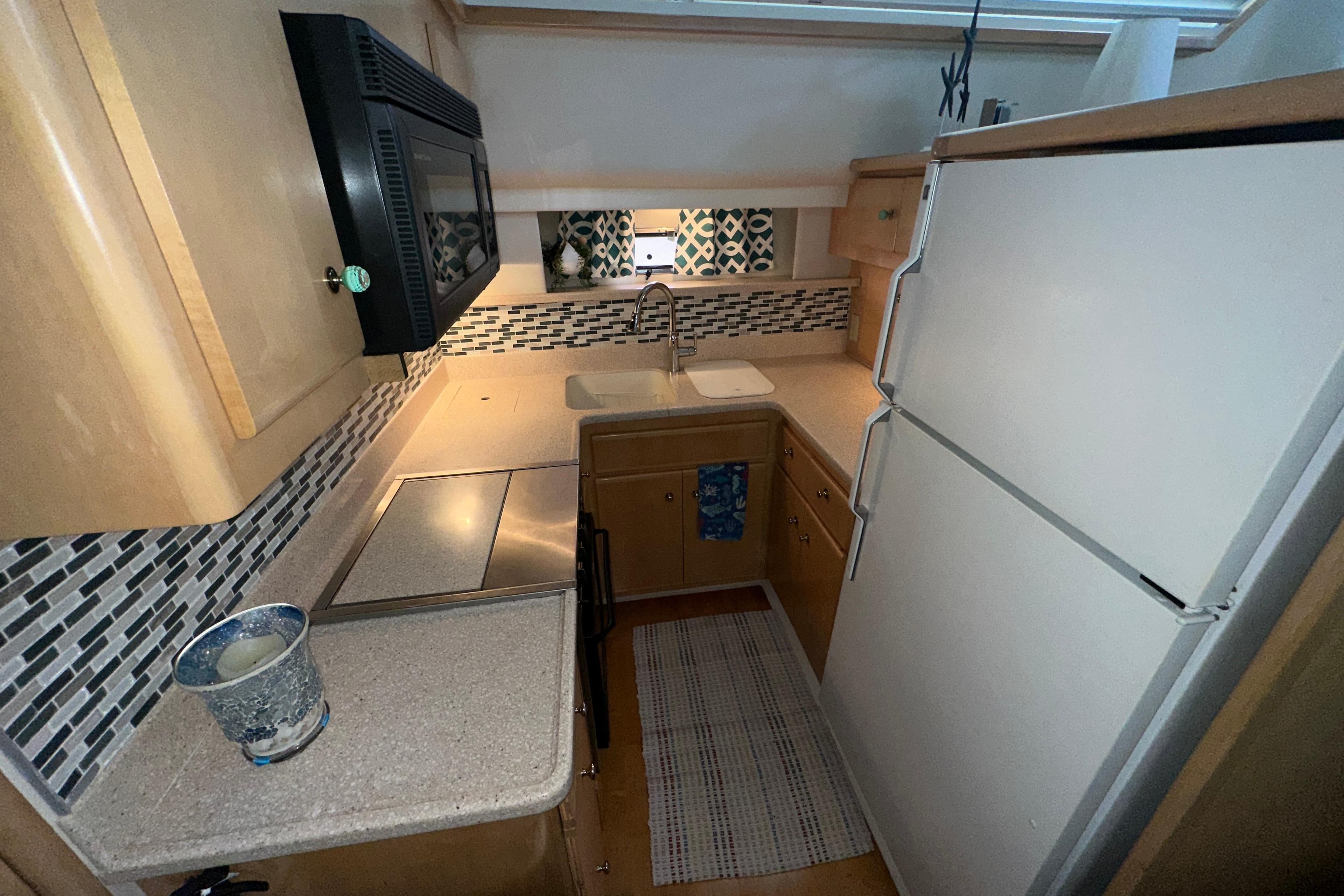 Compact kitchen in 1998 Carver 445 Aft Cabin Motor Yacht with modern appliances.