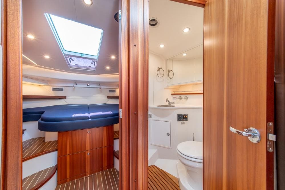 Interior of 2022 Nimbus 405 Coupé yacht, featuring a cozy cabin and modern bathroom.