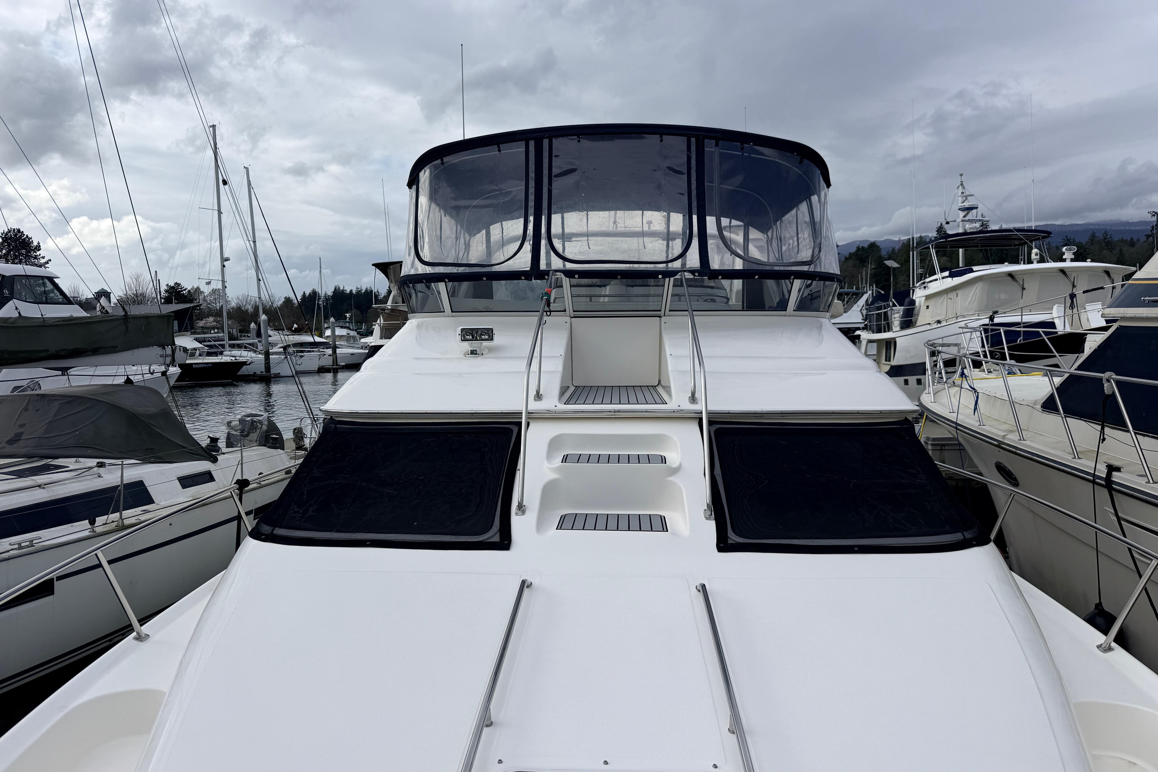 2003 Sea Ray 450 Express Bridge yacht docked at marina, overcast sky.