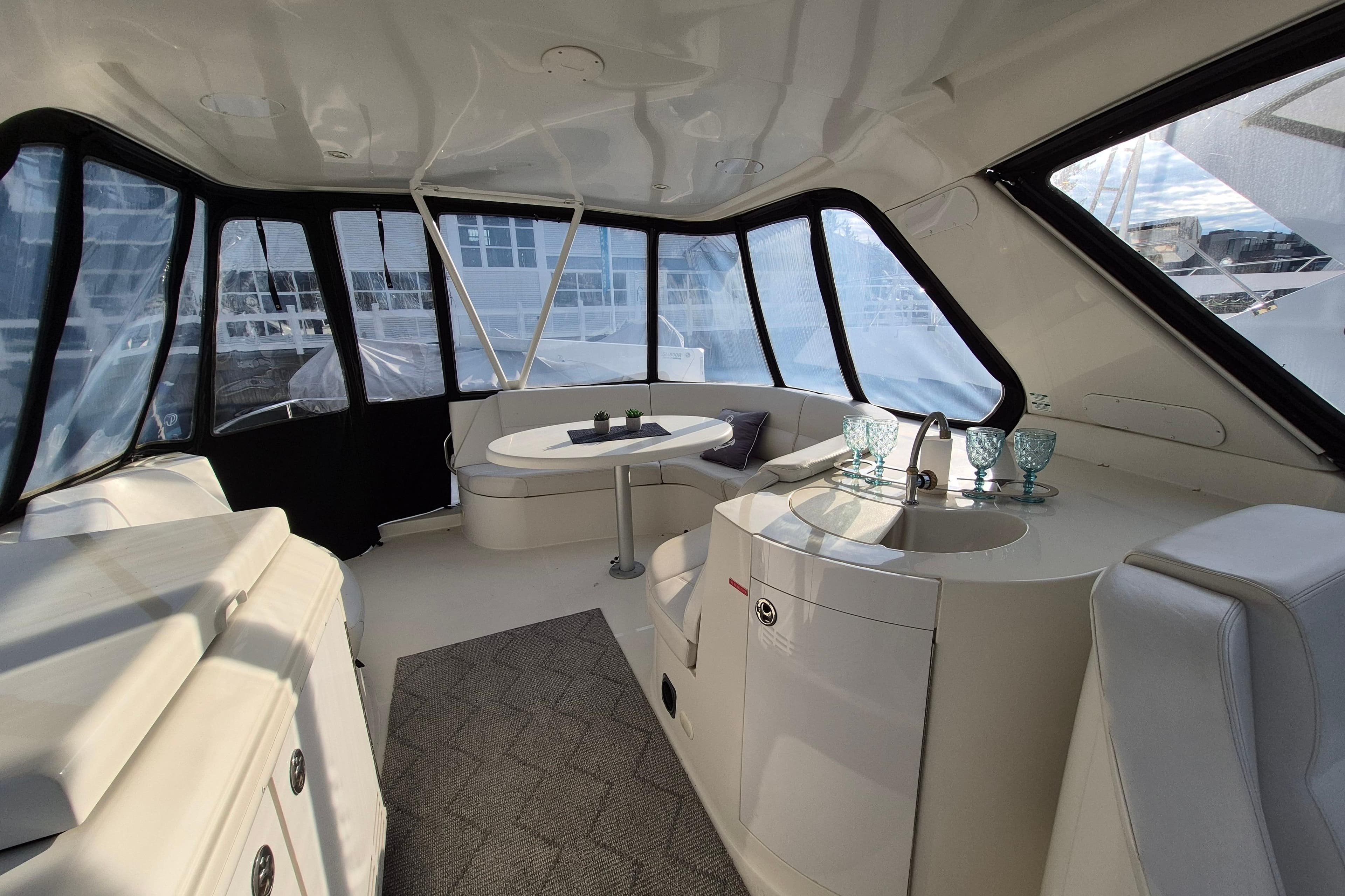 Luxurious interior of 2005 Carver 560 Voyager yacht with seating and kitchenette.