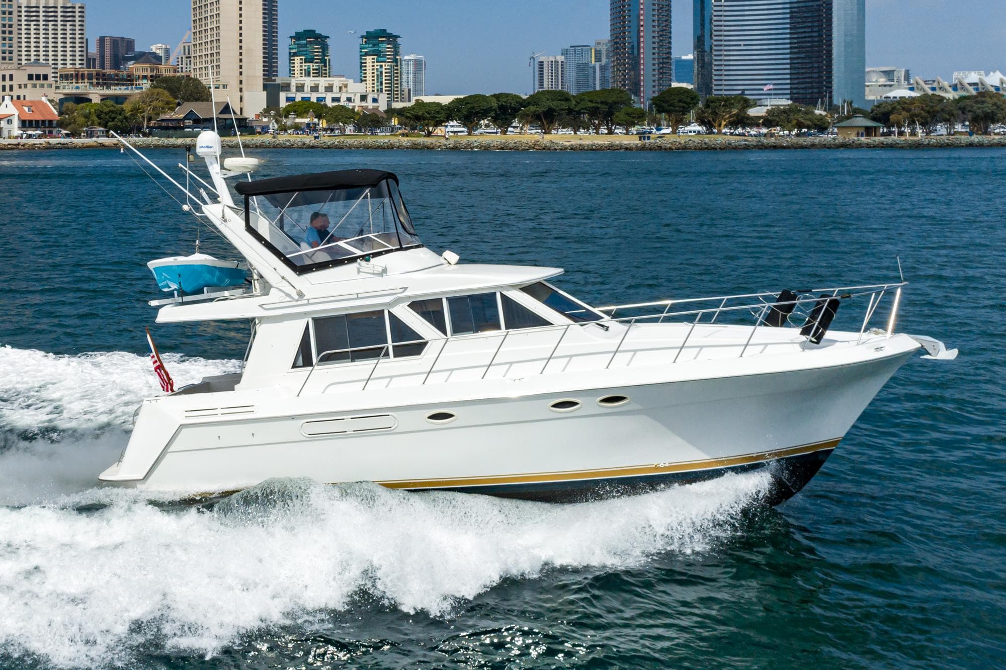1999 Californian 3900 yacht cruising on water near city skyline.