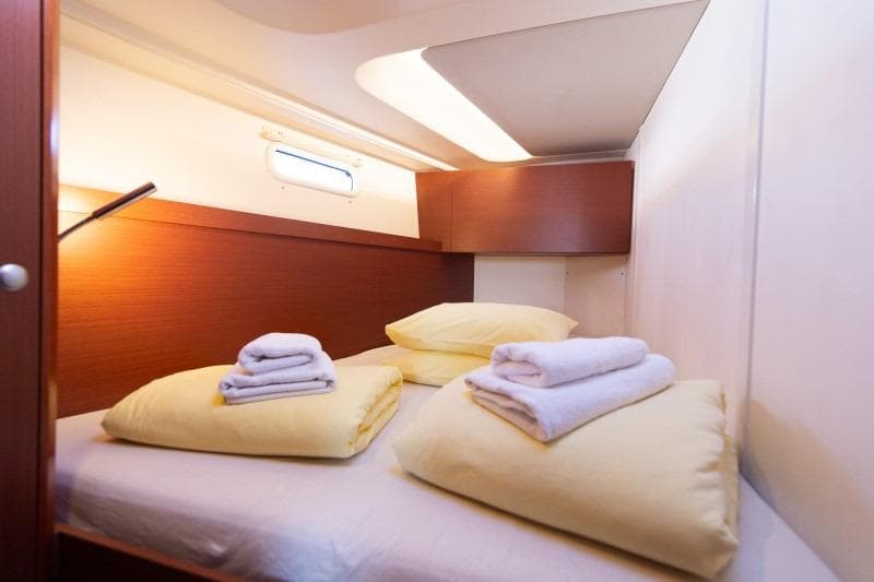 Cozy cabin interior of 2018 Hanse 505 yacht with neatly arranged bedding.