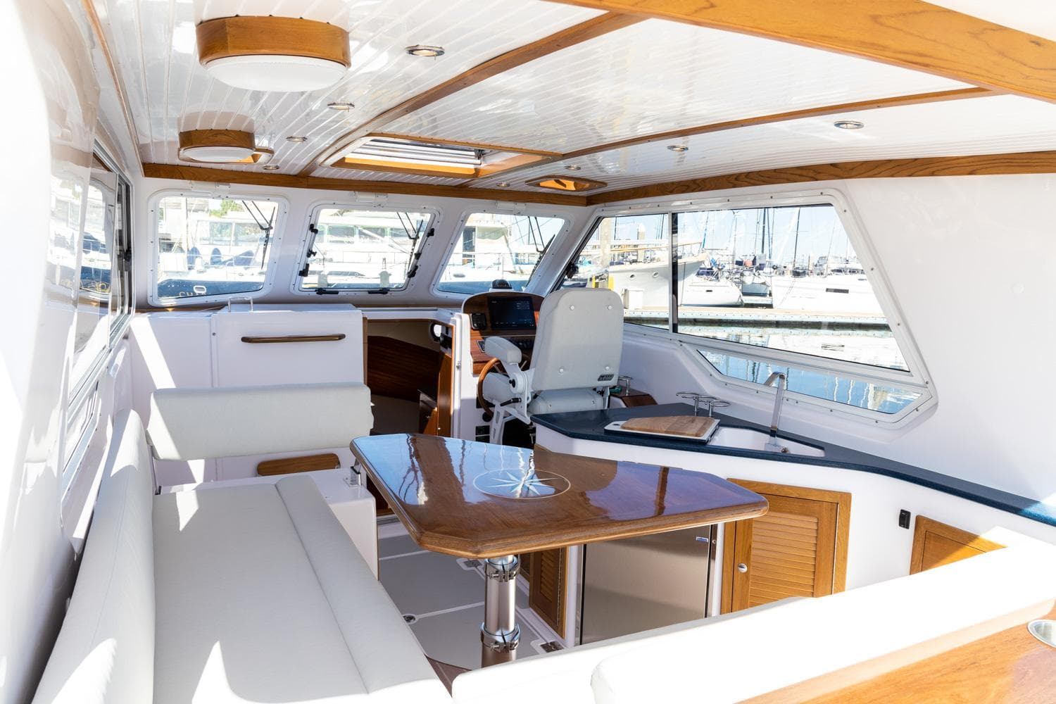 Luxurious interior of 2020 True North 34 yacht with elegant wood finishes and spacious seating.