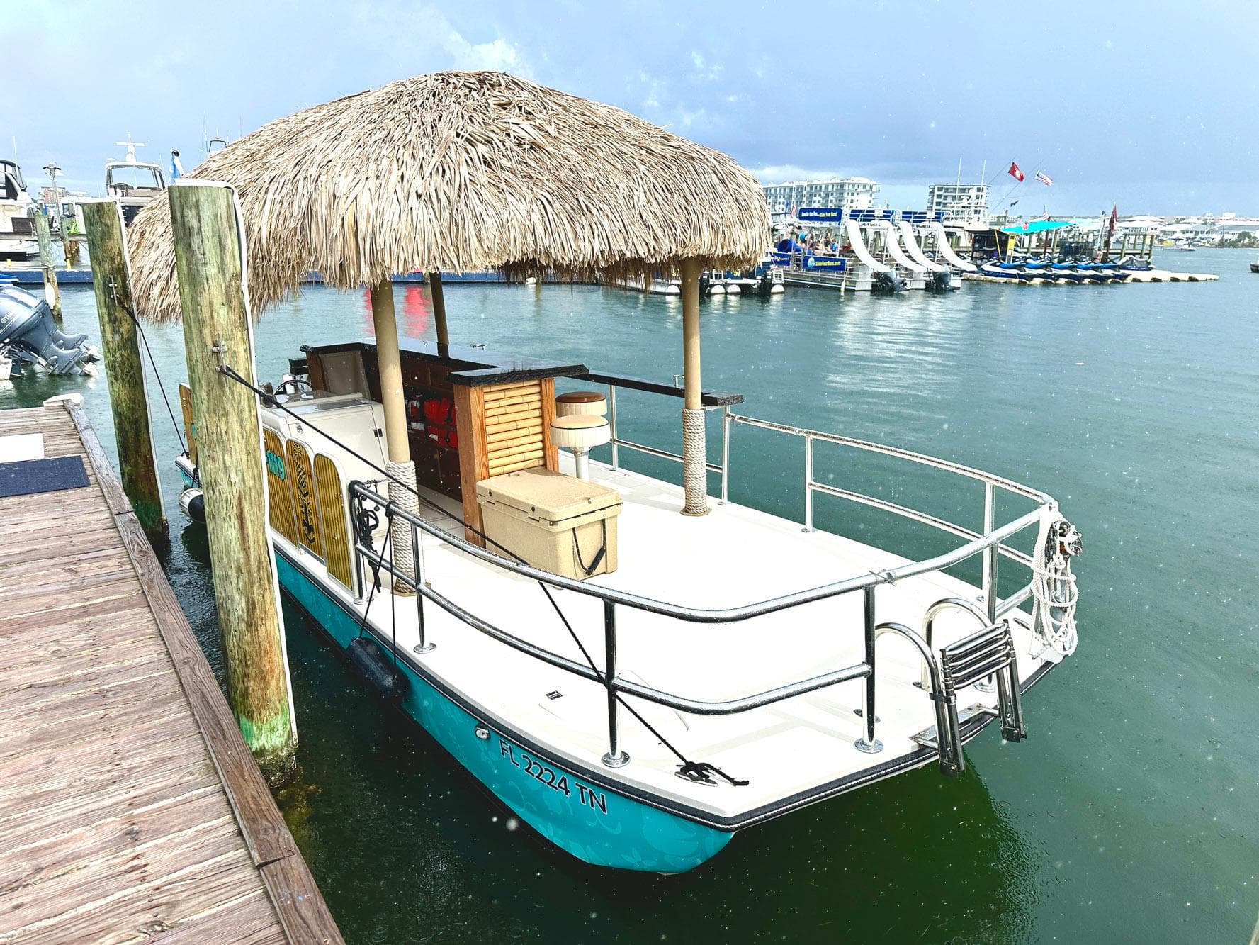 2023 Beachcat 23 Catamaran with tiki-style roof docked at marina.