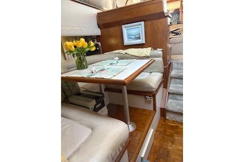 Interior of 1990 Californian 45 Motor Yacht with cozy dining area and floral decor.