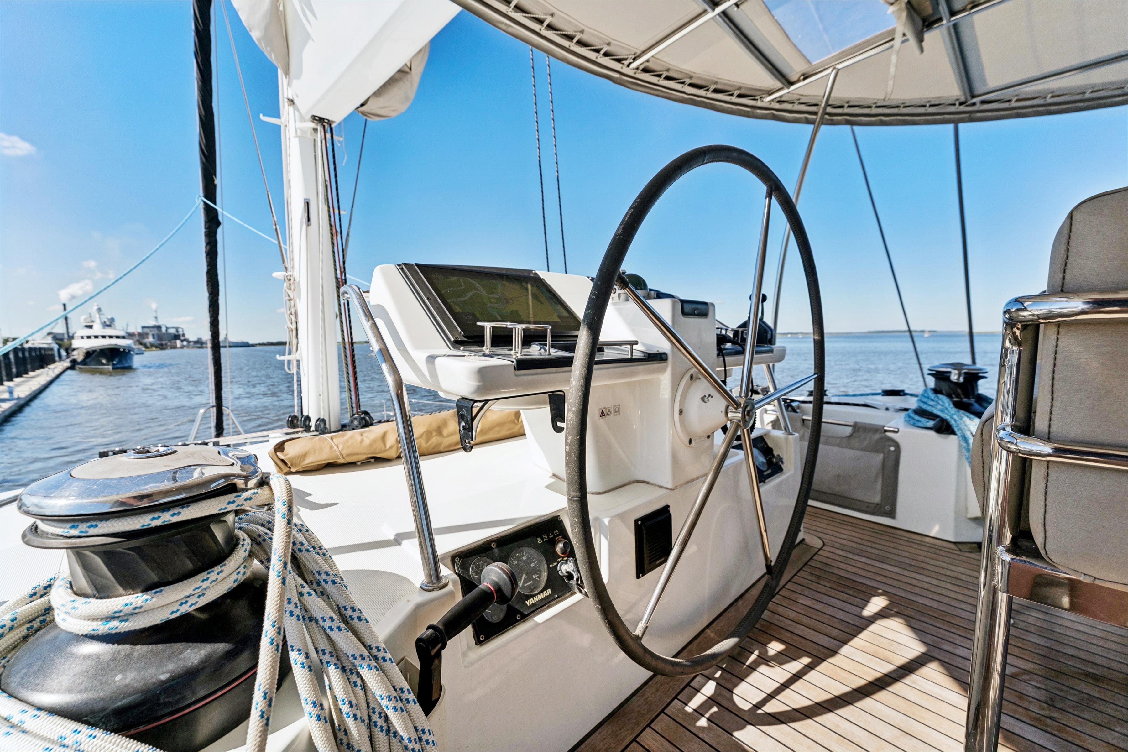 Steering wheel of 2012 Lagoon 560 yacht with ocean view and clear sky.