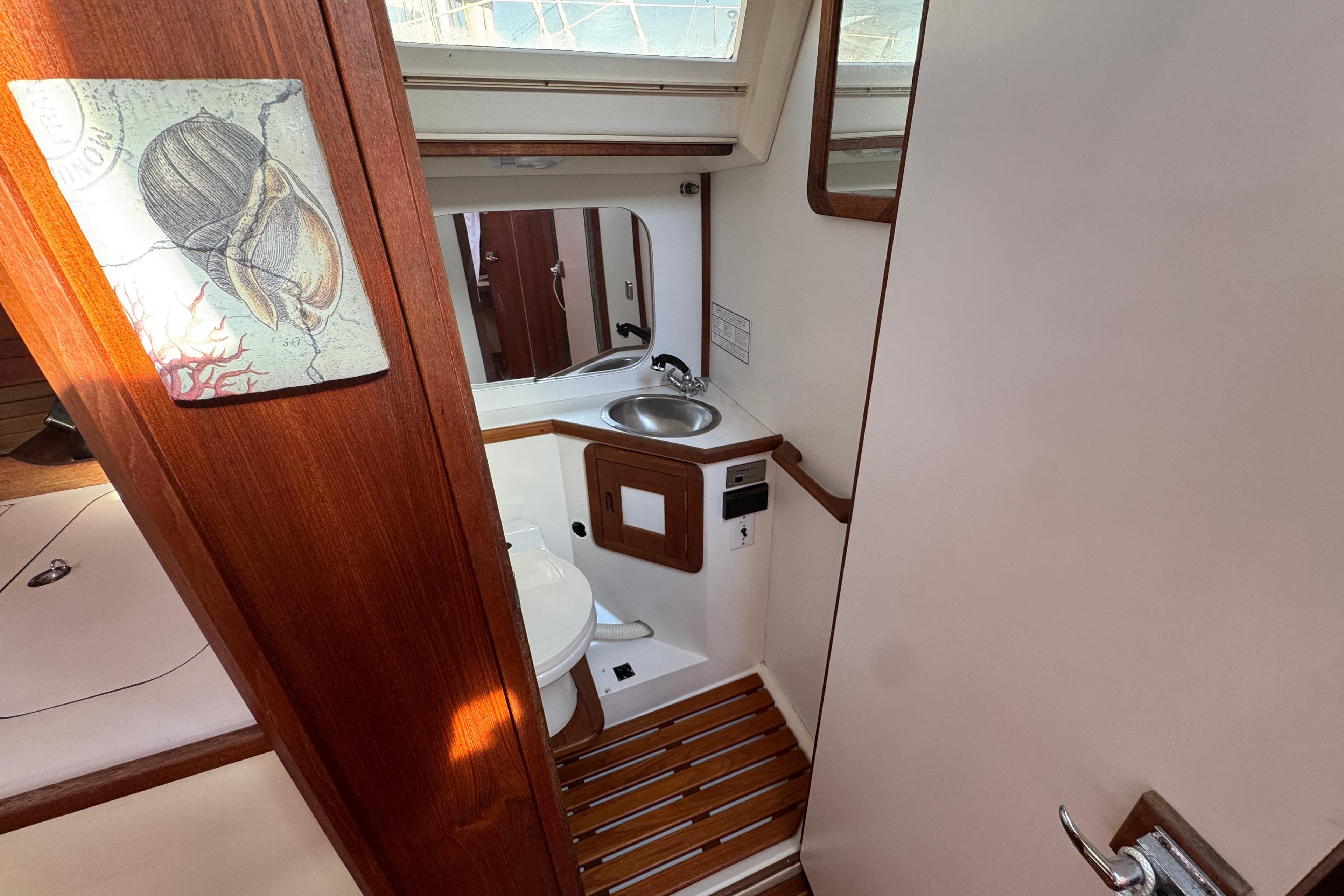 Interior of 1989 Catalina 42 sailboat bathroom with wooden accents and nautical decor.