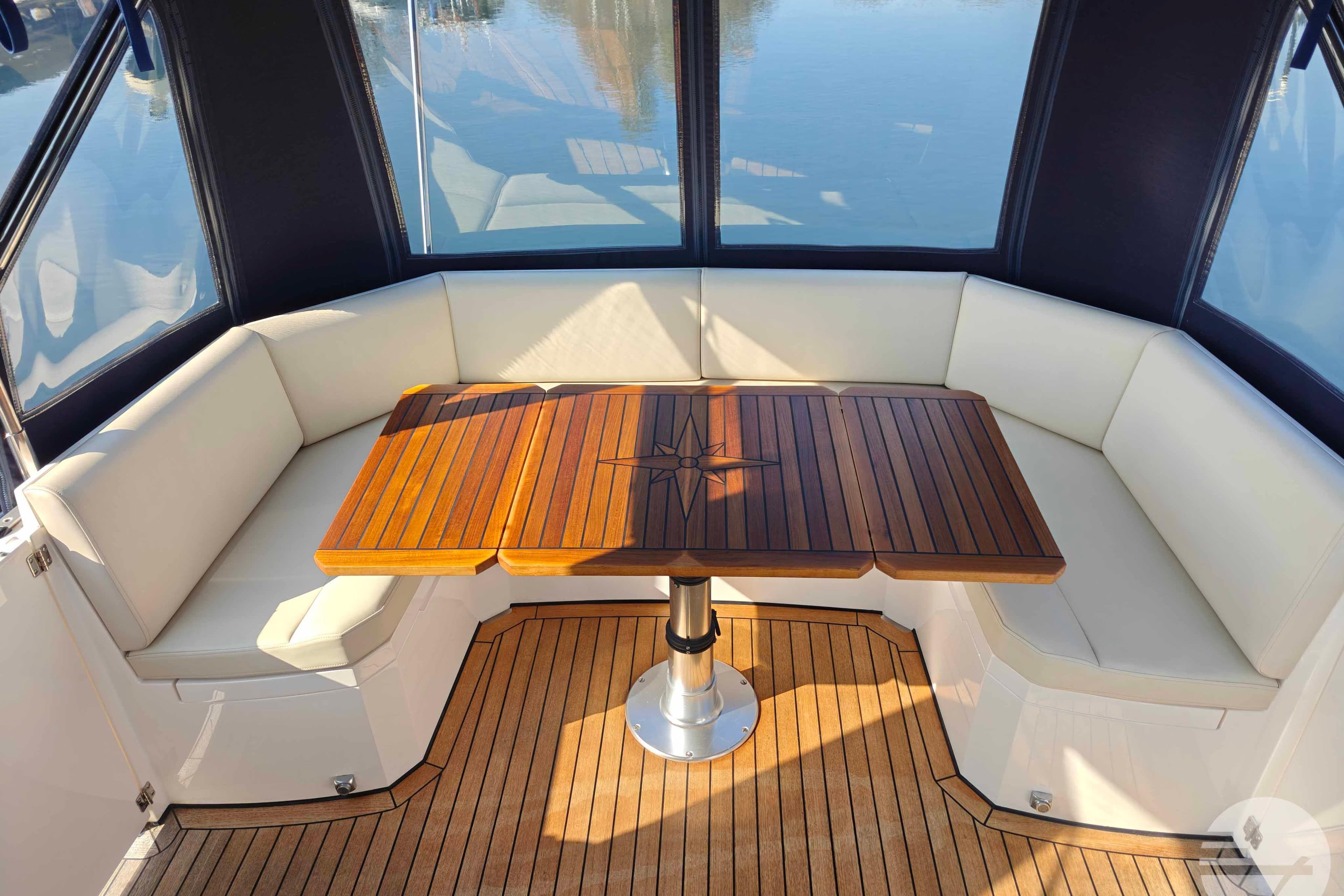 Luxurious Broom 395 boat interior with elegant wooden table and cushioned seating, 2010 model.