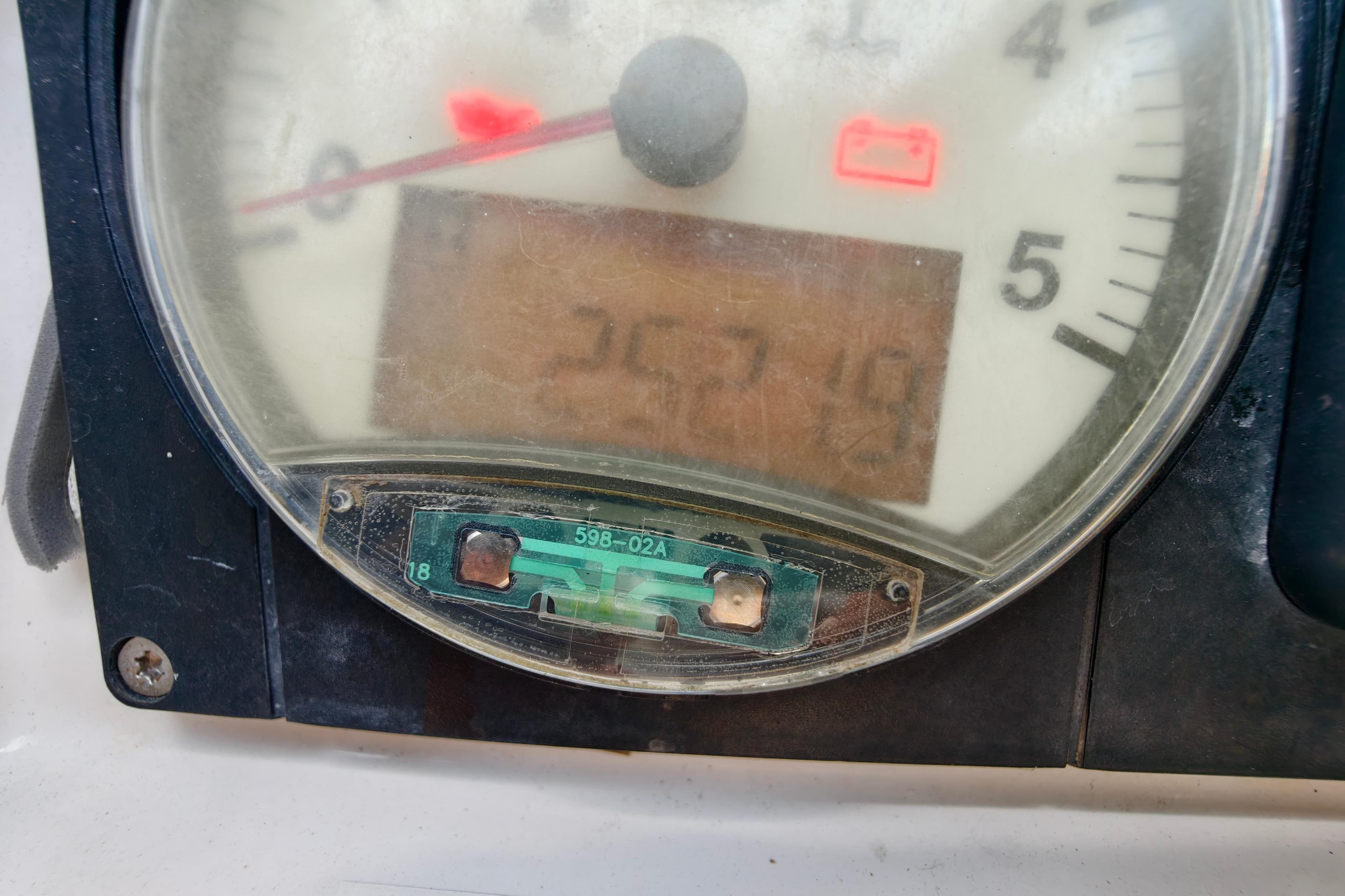 Close-up of Jeanneau Sun Odyssey 509 tachometer, displaying 257.4 hours, with battery warning light.