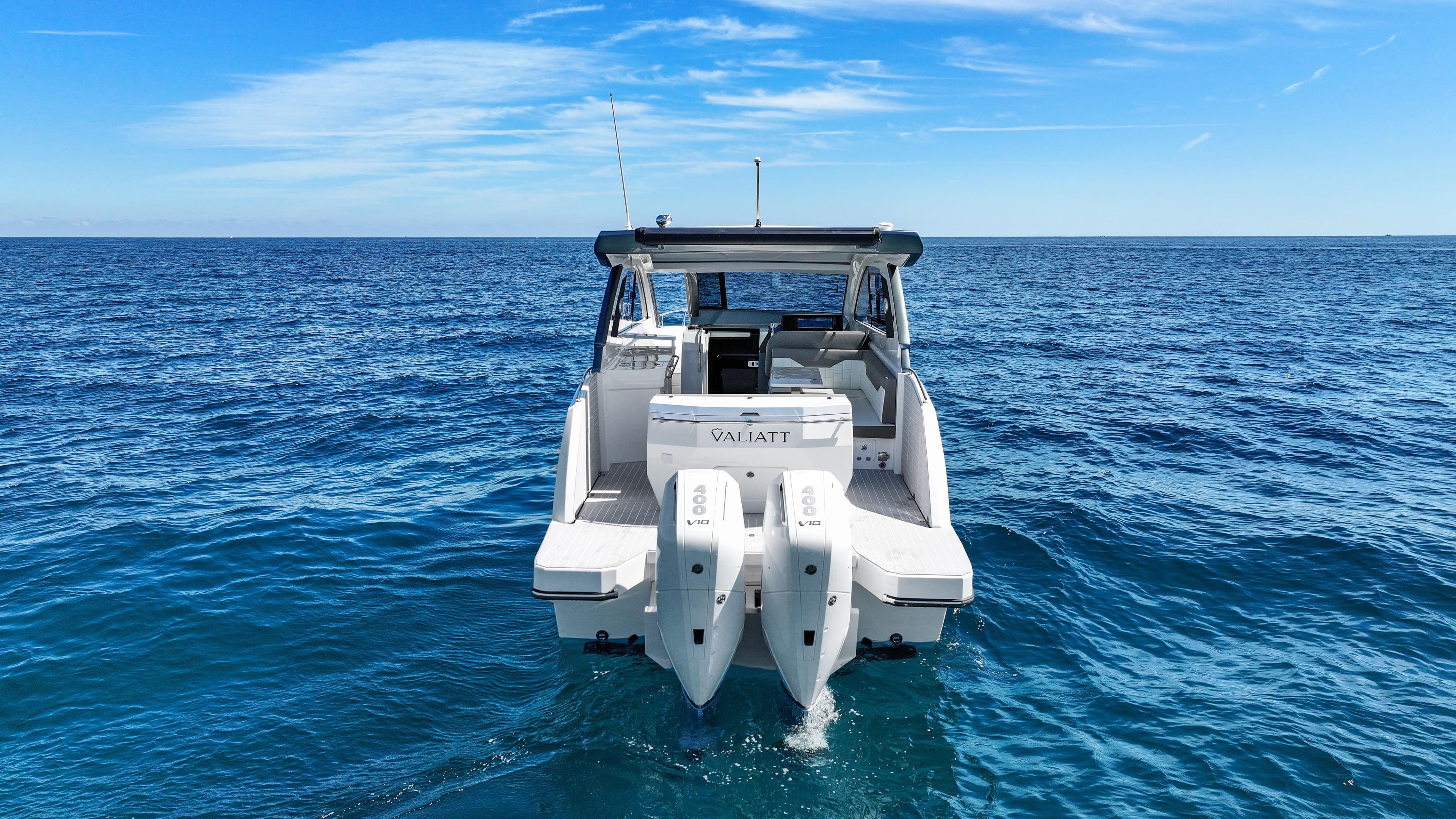2025 Valiatt 380 Bowrider boat on open sea, rear view, clear blue sky.
