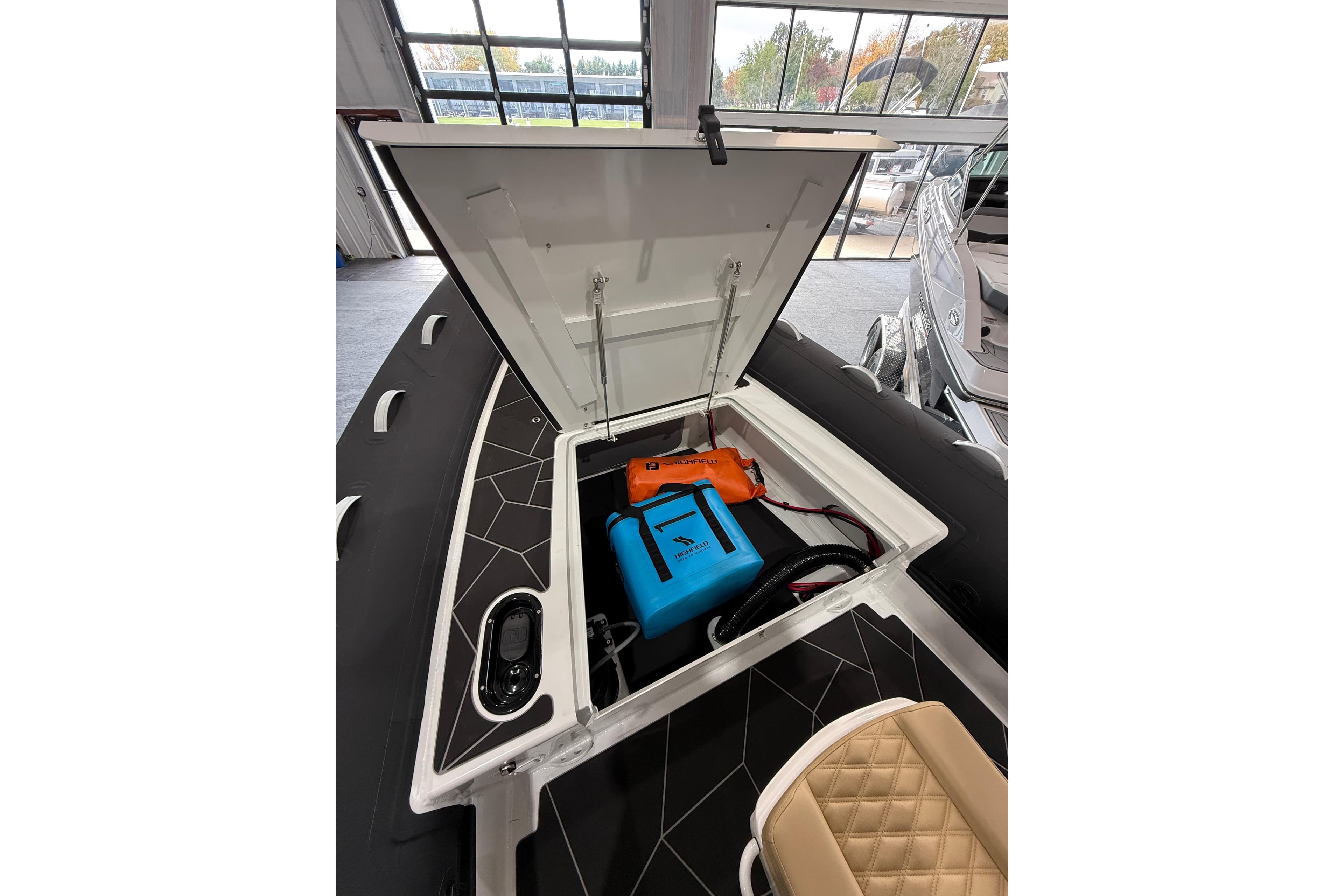 Open storage compartment of 2026 Highfield Sport 800 boat, showcasing interior equipment.