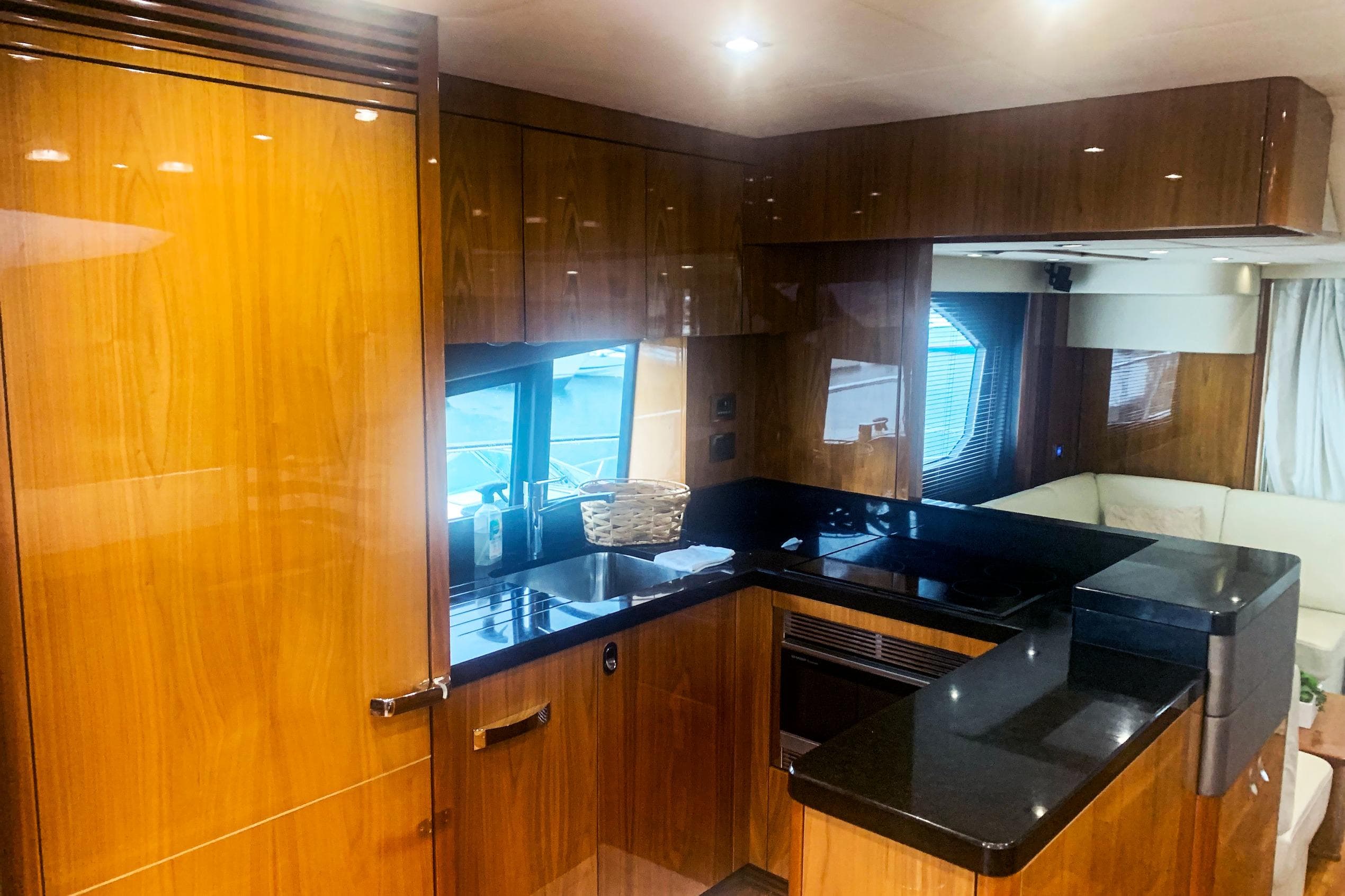 Luxurious kitchen interior of 2016 Sunseeker Manhattan 65 yacht with sleek wood finish.