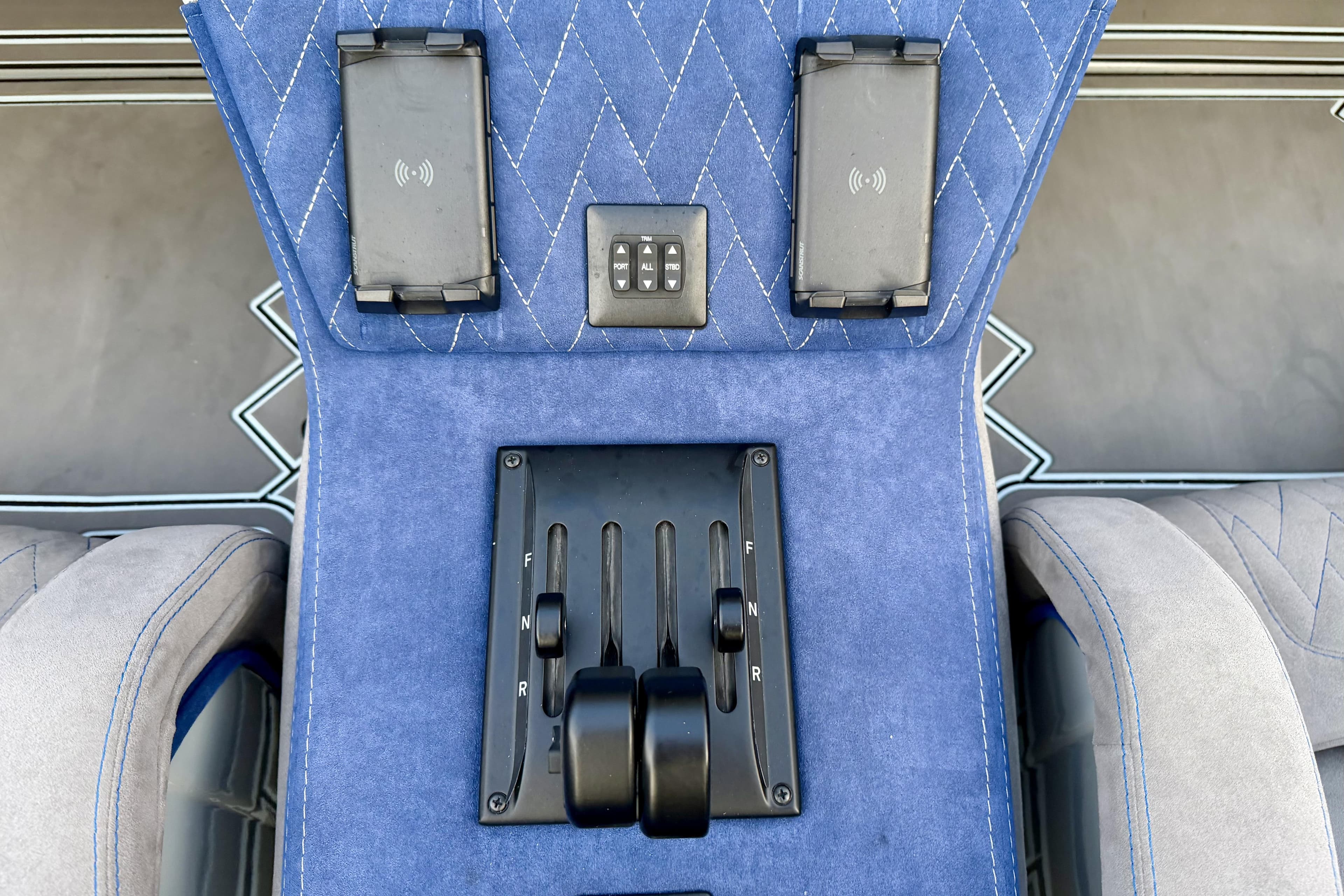 Blue interior of 2024 Dug Wright 32 with control panel and wireless chargers.